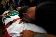 A friend of Reuters videographer Issam Abdallah who was killed by Israeli shelling mourns over his body during his funeral procession in his hometown 