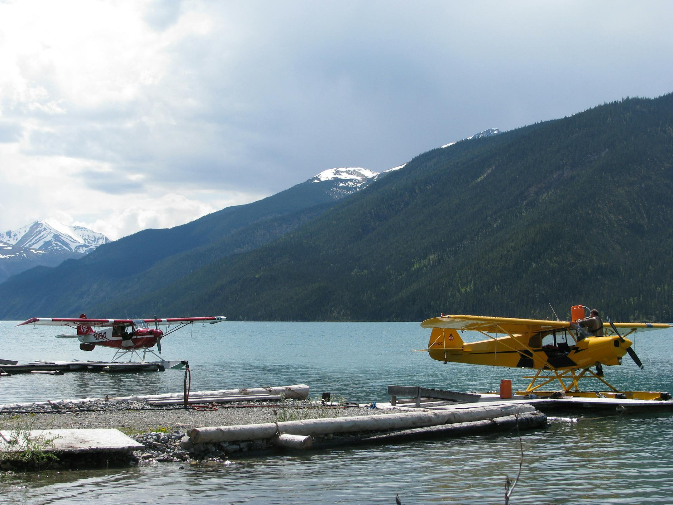 Wolfgang Greiner and Phil Mattison refuel their planes at a mountain lake in the Yukon.