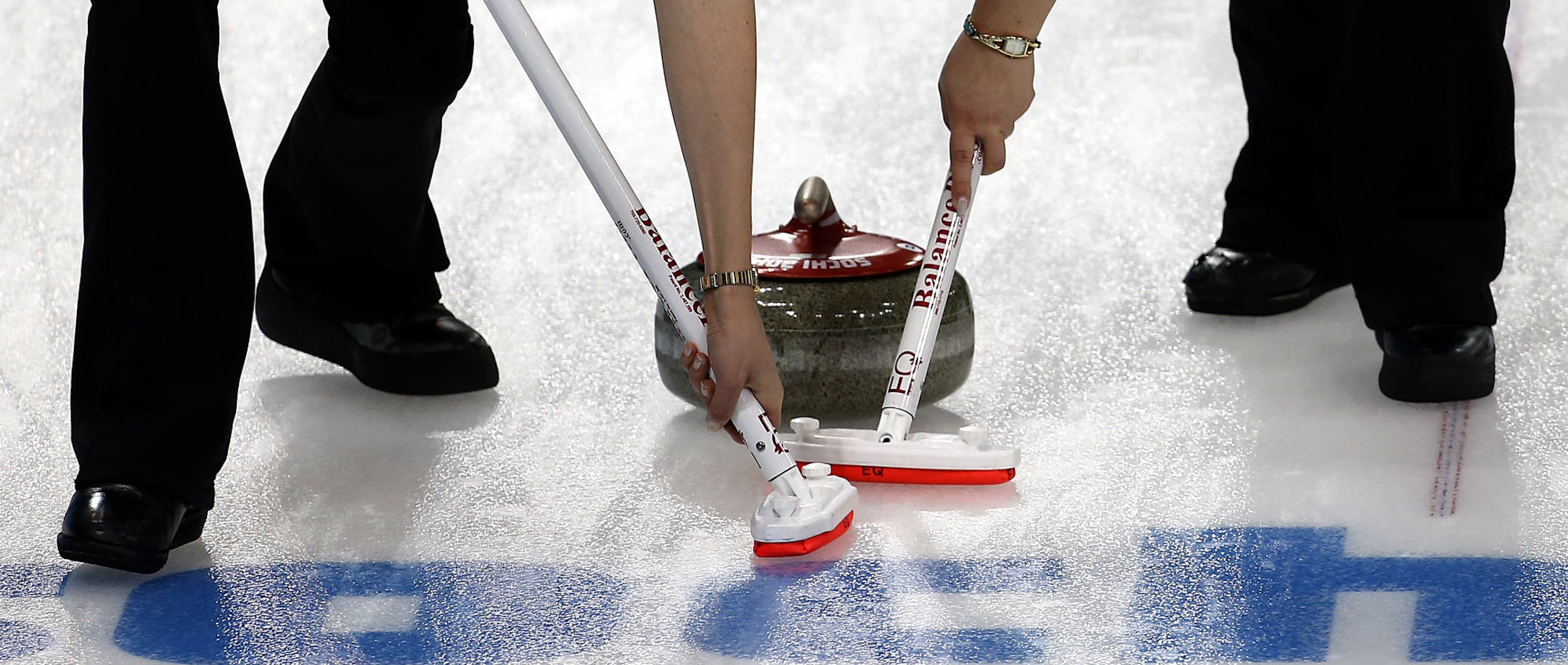 Denmark's Helle Simonsen, left, and Maria Poulsen, right, sweep ahead of the stone during the women's curling match against South Korea at the 2014 Winter Olympics, Sunday, Feb. 16, 2014, in Sochi, Russia. (AP Photo/Wong Maye-E)