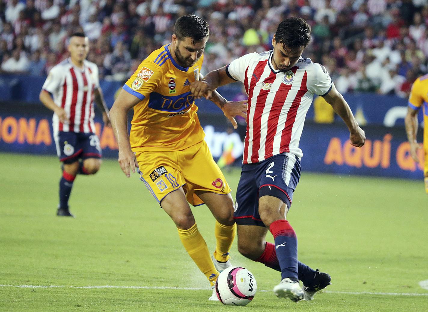 Tigre UANL orward Andre-Pierre Gignac (10), left, and Chivas de Guadalajara defender Oswaldo Alanis (2) battle in the first half of a Champion of Champions (Campeon de Campeones) soccer match in Carson, Calif., Sunday, July 16, 2017. (AP Photo/Reed Saxon)