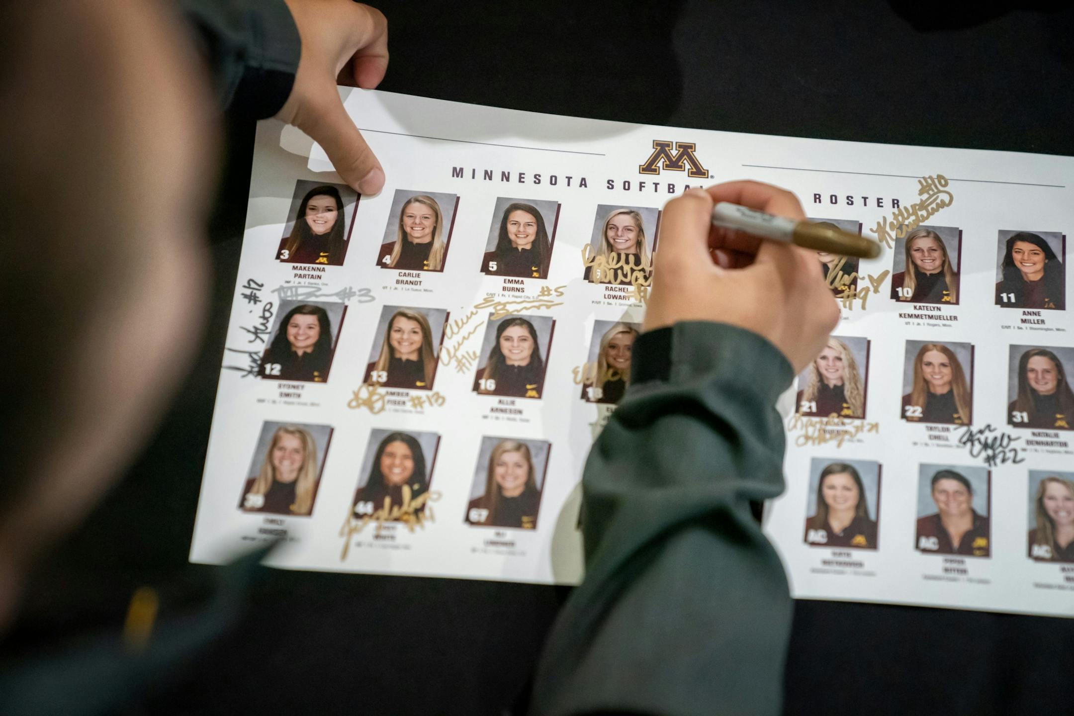 Allie Areneson signed a team roster for a fan. The Gophers softball team has a rally/autograph session before heading to Oklahoma City for the Women's College World Series. This was in the lobby of the Athletes Village.