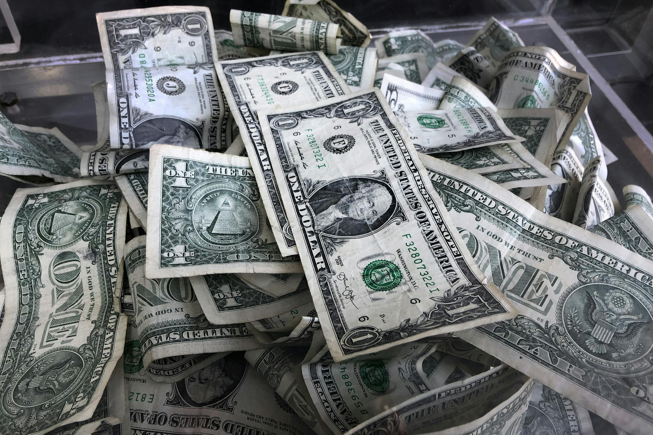 FILE - In this Wednesday, April 3, 2019, file photo, a tip box is filled with dollar bills, in New York. The minimum wage is rising to $15 for all workers in New York City, as of Dec. 31, 2019. Workers elsewhere in the state will make less: $13 in the city's near suburbs and $11.80 upstate. (AP Photo/Mark Lennihan, File)