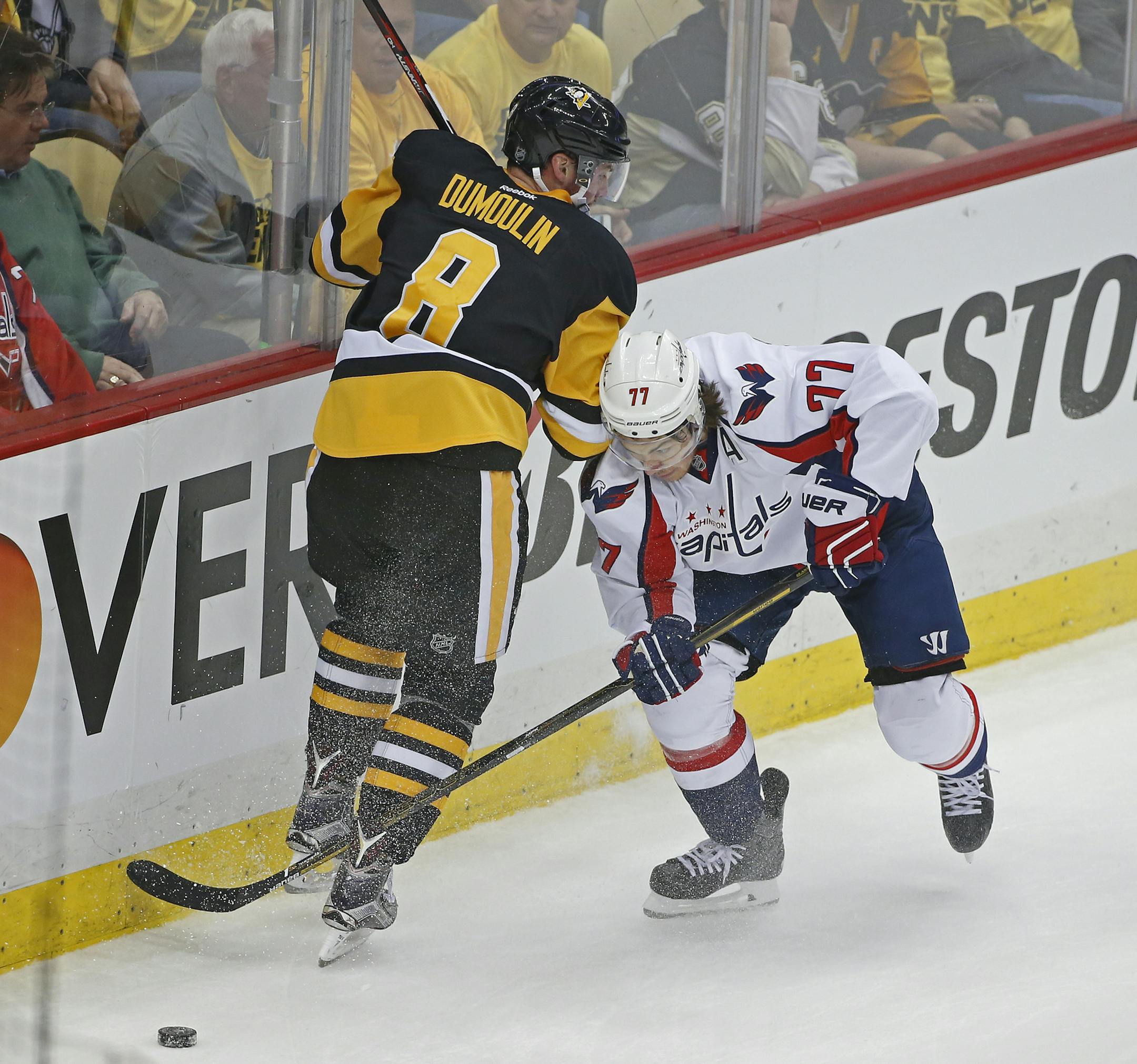Washington Capitals T.J. Oshie (77) skates past Pittsburgh Penguins Brian Dumoulin (8) during the first period of Game 3 in an NHL hockey Stanley Cup Eastern Conference semifinals in Pittsburgh, Monday, May 2, 2016. (AP Photo/Gene J. Puskar)