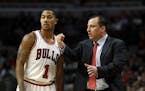 Chicago Bulls point guard Derrick Rose (1) talks with head coach Tom Thibodeau during the first half of an NBA game against the Detroit Pistons at the
