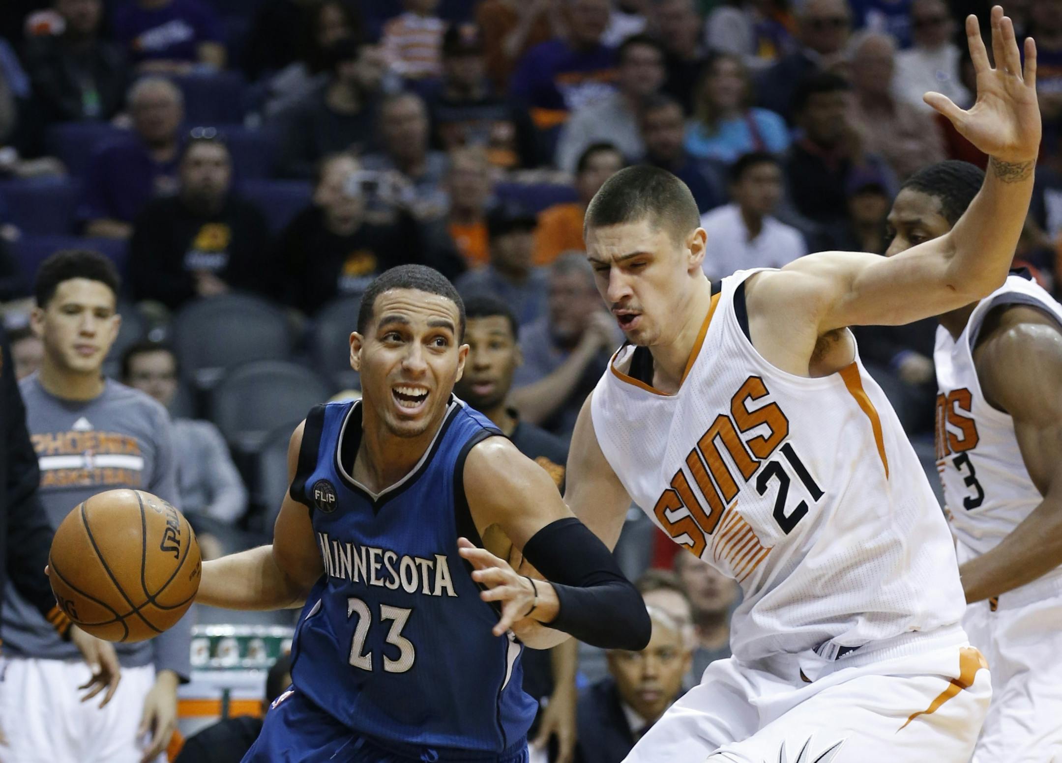 Minnesota Timberwolves' Kevin Martin (23) drives past Phoenix Suns' Alex Len (21), of Ukraine, during the second half of an NBA basketball game Sunday, Dec. 13, 2015 in Phoenix. The Suns defeated the Timberwolves 108-101.