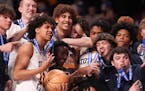 Totino-Grace players celebrated with their first place trophy after winning the MSHSL boys basketball Class 3A state championship game between Totino-