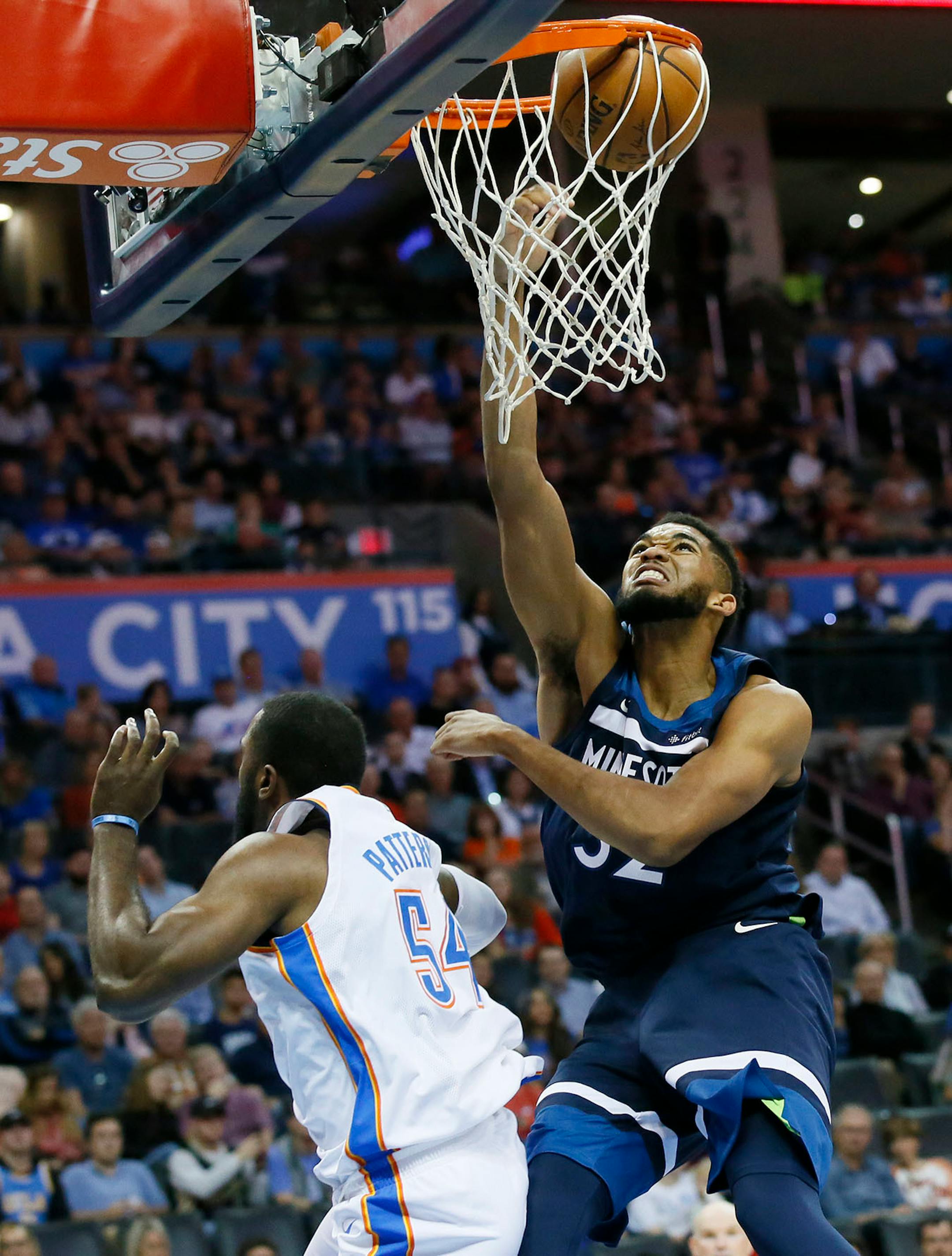 Minnesota Timberwolves center Karl-Anthony Towns (32) dunks over Oklahoma City Thunder forward Patrick Patterson (54) in the second quarter of an NBA basketball game in Oklahoma City, Sunday, Oct. 22, 2017.
