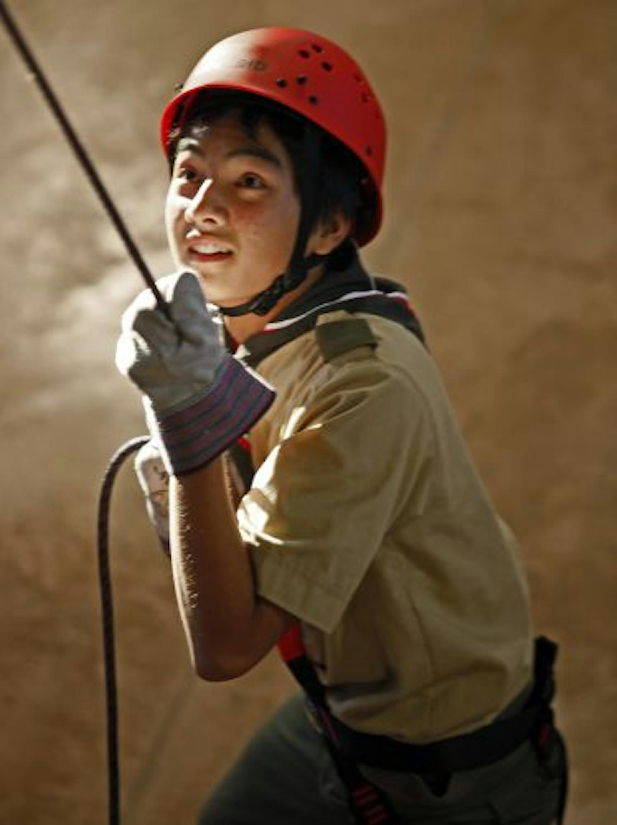 Boy Scout Johnny Her, 15, of Minneapolis steadied and shouted encouragement to another boy climbing a rock wall at the Northern Star Council's new Base Camp at Fort Snelling.