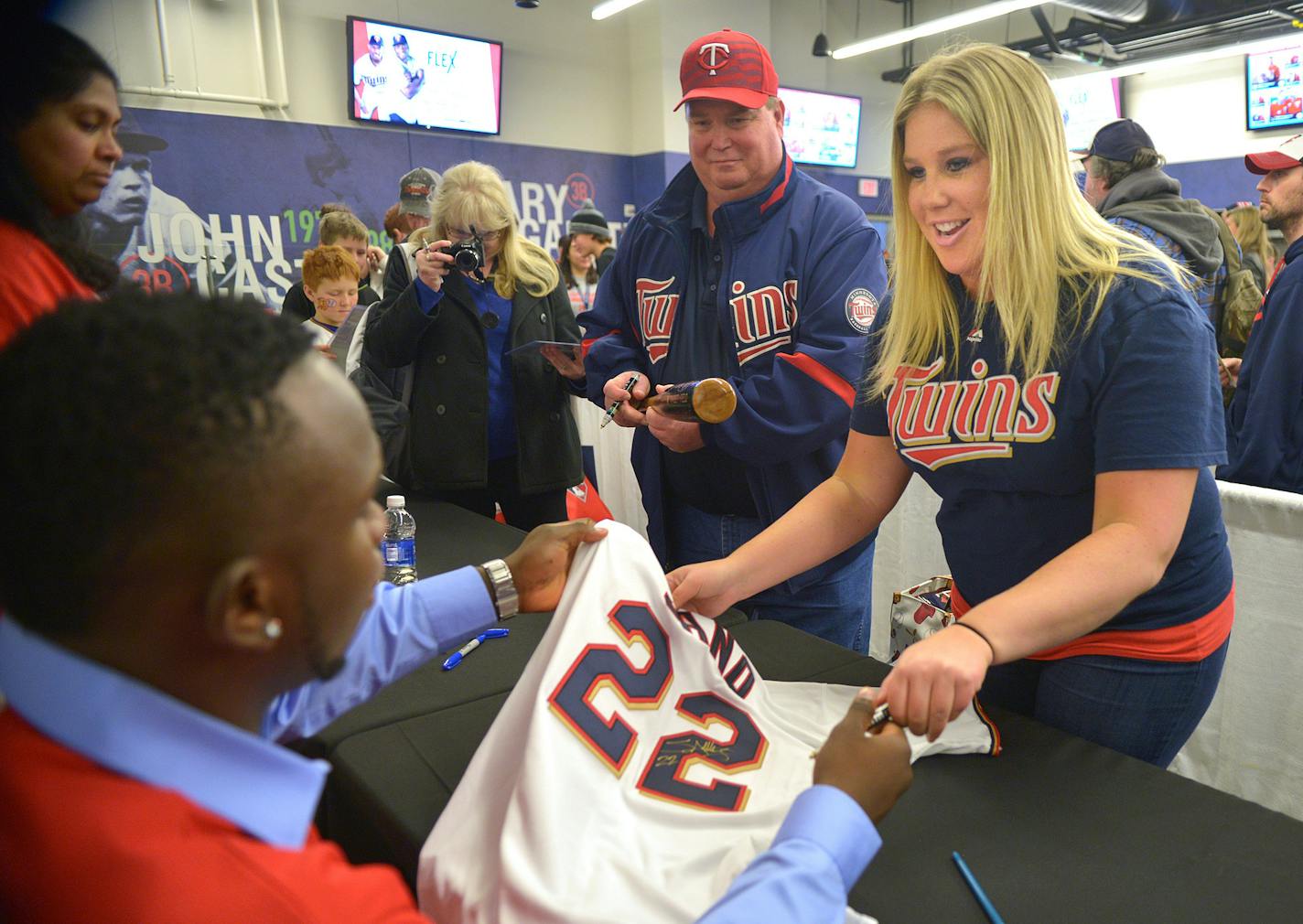 Sano signs a replica jersey for Chelsea Beaver, 29 and her dad Randy Beaver, of Verndale, Minn. at TwinsFest