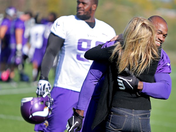 Minnesota Vikings Adrian Peterson received a hug from an unidentified person during practice at Winter Park, Friday, October 11, 2013 in Eden Prairie,