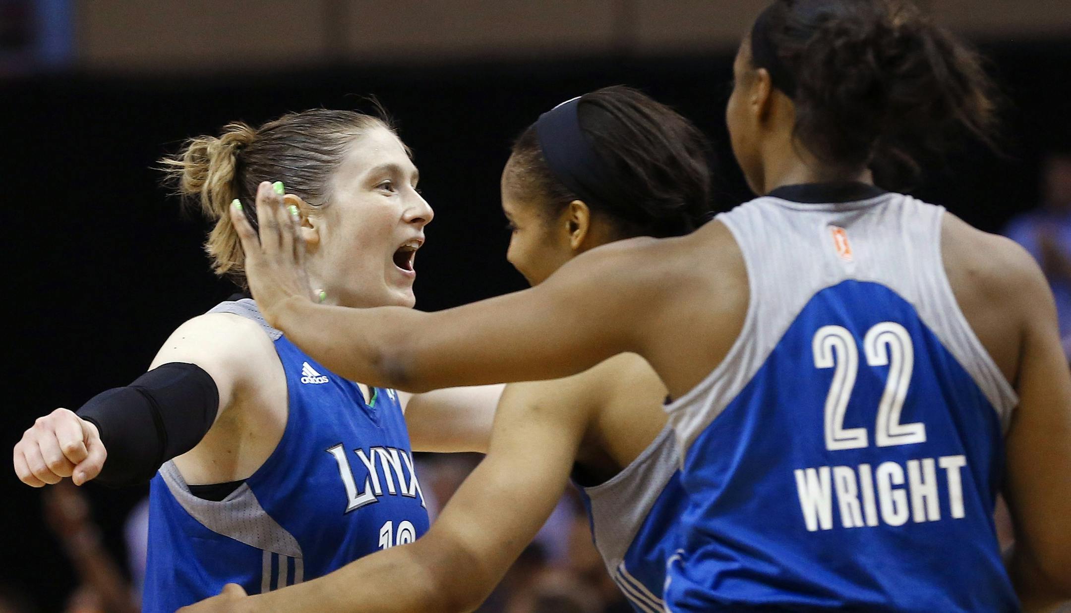 Minnesota Lynx's Lindsay Whalen, left, celebrates a win over the Phoenix Mercury with teammates Monica Wright (22) and Maya Moore as time expires in a WNBA Western Conference Finals basketball game on Sunday, Sept. 29, 2013, in Phoenix. The Lynx defeated the Mercury 72-65, and won the Western Conference Finals 2-0, earning a trip to the WNBA Finals to face the Atlanta Dream. (AP Photo/Ross D. Franklin)