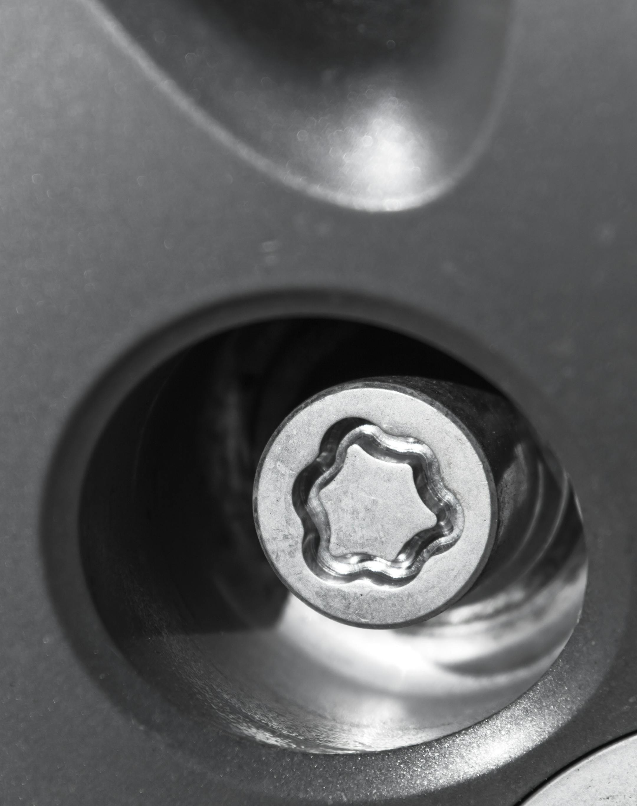 Car wheel lock nut, theft protection, close up photo with selective focus