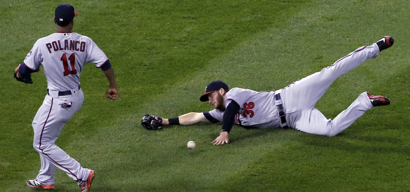 Minnesota Twins left fielder Robbie Grossman, right, cannot make the play on a single by Chicago White Sox's Melky Cabrera as shortstop Jorge Polanco, left, looks on during the fourth inning of a baseball game Friday, Sept. 30, 2016, in Chicago. (AP Photo/Nam Y. Huh)