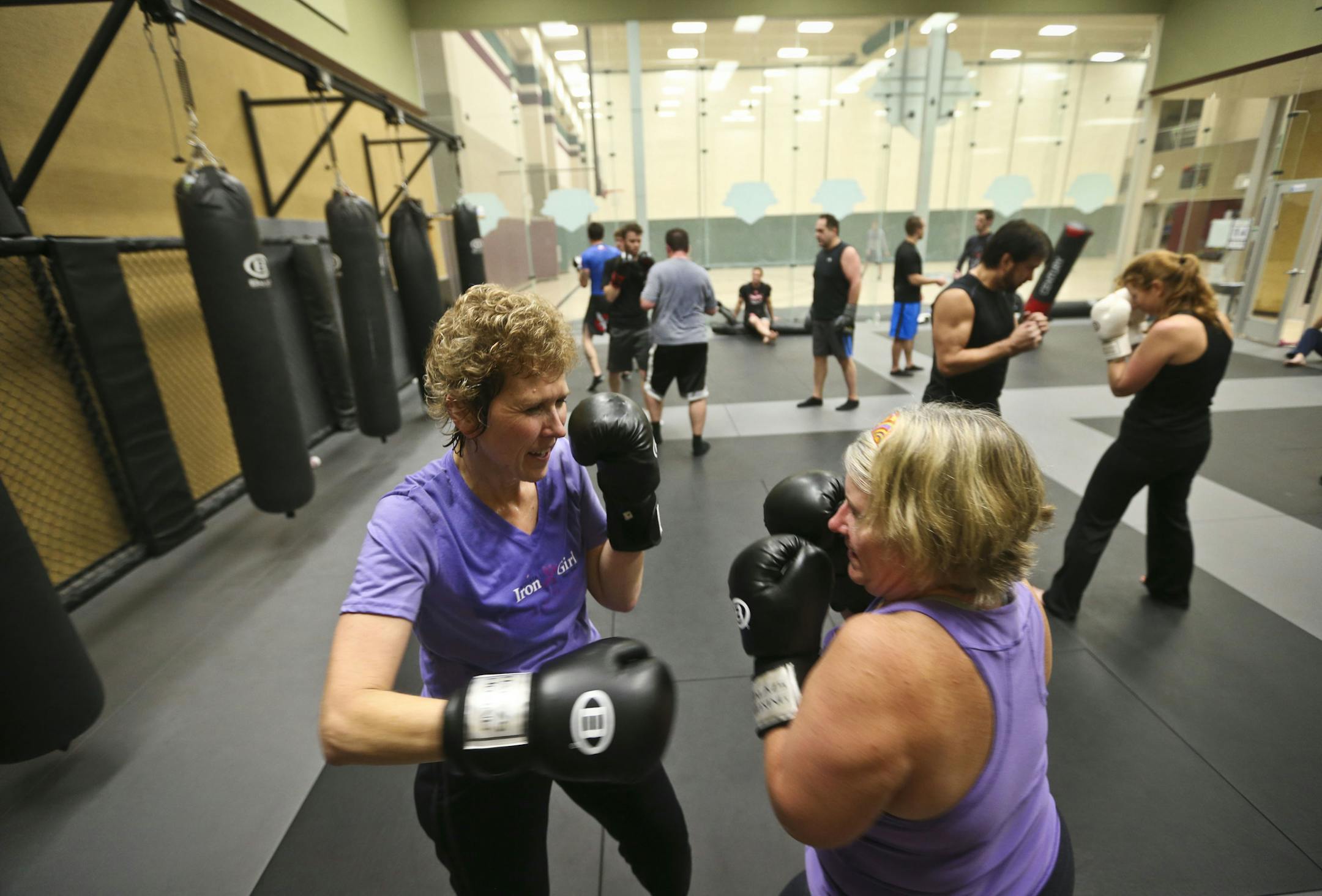 Julie Bruce, 49, of Shakopee, left, sparred with Diane Crist, 52, of Shakopee, during a Mixed Martial Arts workout class called "Fight Shape" at Lifetime Fitness on Monday, November 11, 2013 in Chanhassen, Minn. ] RENEE JONES SCHNEIDER • reneejones@startribune.com