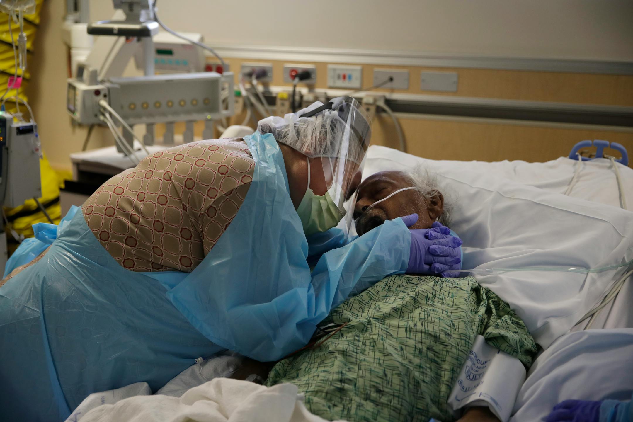 Romelia Navarro, 64, wept while hugging her husband, Antonio, in his final moments in a COVID-19 unit at St. Jude Medical Center in Fullerton, Calif., in July. In November 2020, California is reaching an unwelcome coronavirus record: its 1 millionth positive test.