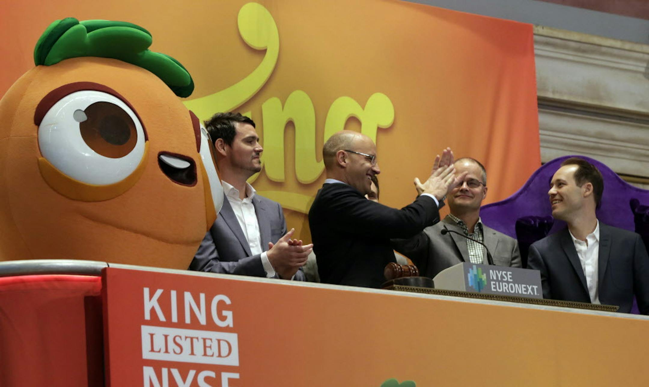 King Digital Entertainment CEO and founder Riccardo Zacconio second left, high-fives with company co-founder Lars markgren, the maker of Candy Crush Saga and Farm Heroes Saga, during opening bell ceremonies at the New York Stock Exchange, before King Digital's IPO, Wednesday, March 26, 2014. The stock market opened higher Wednesday after a strong report on American manufacturing. The maker of the hit game "Candy Crush Saga" flopped in its market debut.(AP Photo/Richard Drew)