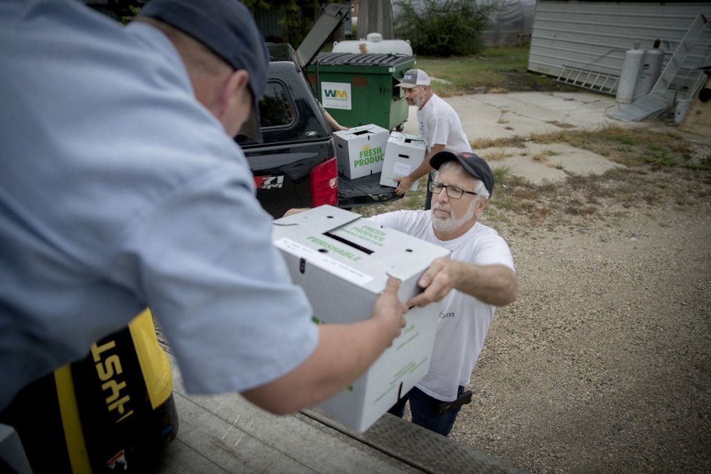 Les Olson of "Big Stone Garlic" center, and his garlic-farmer partner Russ Swenson, left, loaded their first shipment of garlic onto a semi outside Bonnie's Hometown Grocery, Tuesday, September 4, 2018 in Clinton, MN. The garlic will then be taken to a warehouse in Wadena and sold to whichever grocery stores want it.