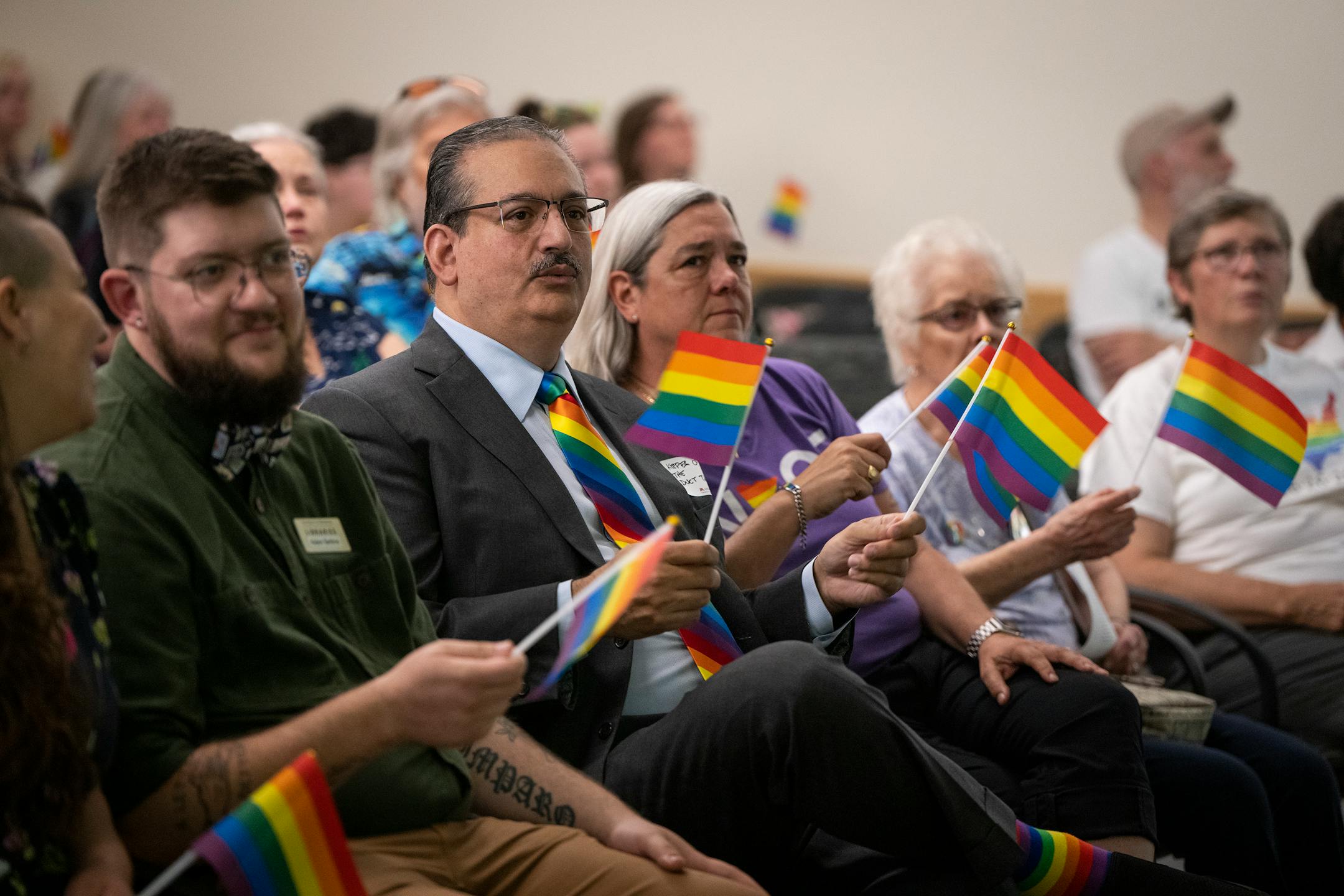 James Garlough, center, a friend of Tretter's and the MC for the event, got emotional as they sang "Somewhere Over the Rainbow" while waving rainbow flags to end the celebration of life for Jean-Nickolaus Tretter.