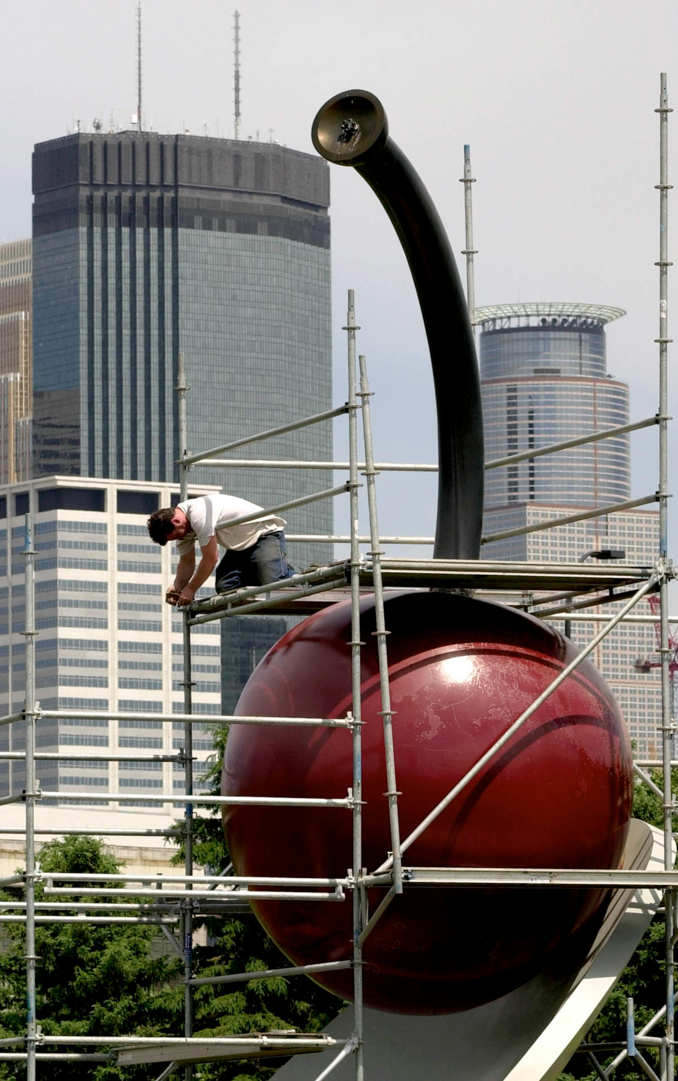 Jason Lowe places scaffolding around the "Spoonbridge and Cherry" sculpture in preparation for sanding and painting the sculpture on May 23, 2000.