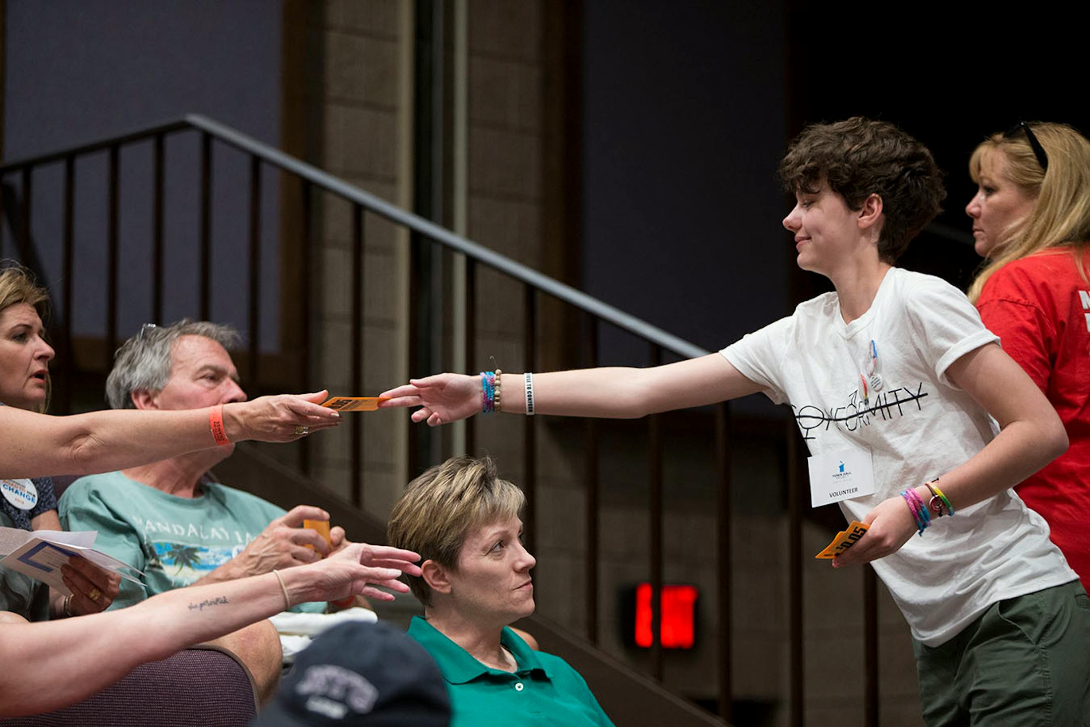 Sydney Lewis hands out small $0.05 coupons representing how many students there are in Minnesota divided by the amount of money Minnesota Congressmen Erik Paulsen and Collin Peterson receive from the NRA.