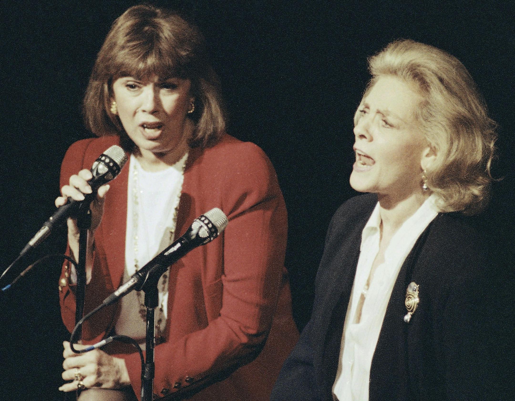 FILE - In this Dec. 13, 1990, file photo, Phyllis Newman, left, and Lauren Bacall sing during a tribute to the late conductor Leonard Bernstein, at New York's Majestic Theatre. Newman, a Tony Award-winning Broadway veteran who became the first woman to host “The Tonight Show” before turning her attention to fight for women’s health, died Sunday, Sept. 15, 2019, in New York. She was 86. (AP Photo/Mark Lennihan, File)