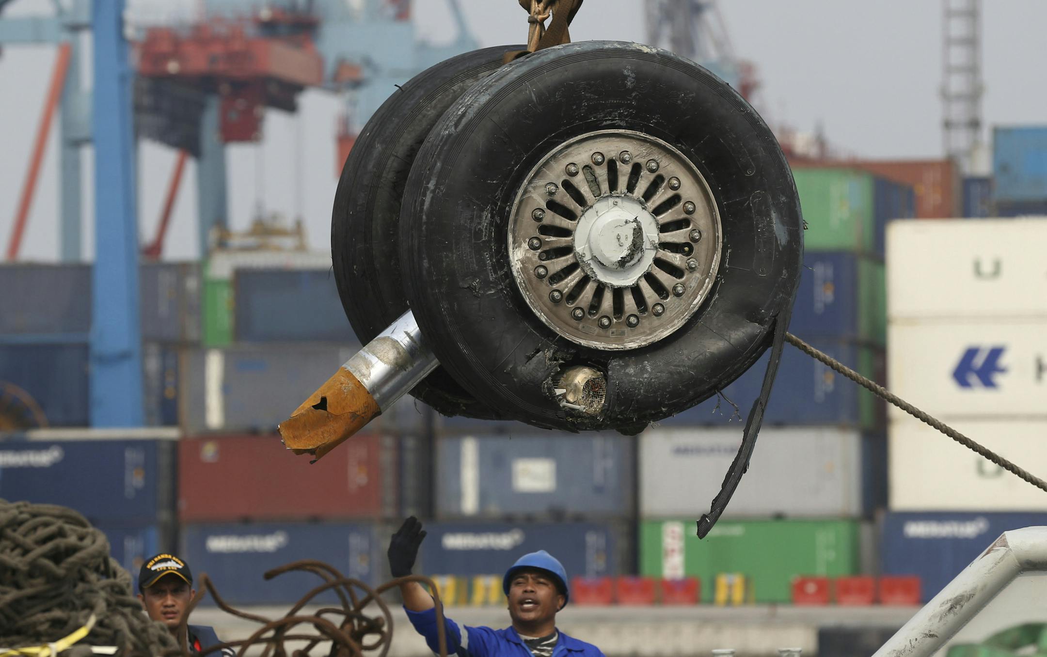FILE - In this Saturday, Nov. 3, 2018, file photo, a crane moves a pair of wheels recovered from the Lion Air jet that crashed into the Java Sea for further investigation at Tanjung Priok Port in Jakarta, Indonesia. Indonesia's transport safety board chair said during a press conference, Thursday, March 21, 2019, that a third pilot was in the cockpit of penultimate Lion Air flight before the crash. (AP Photo/Achmad Ibrahim, File)