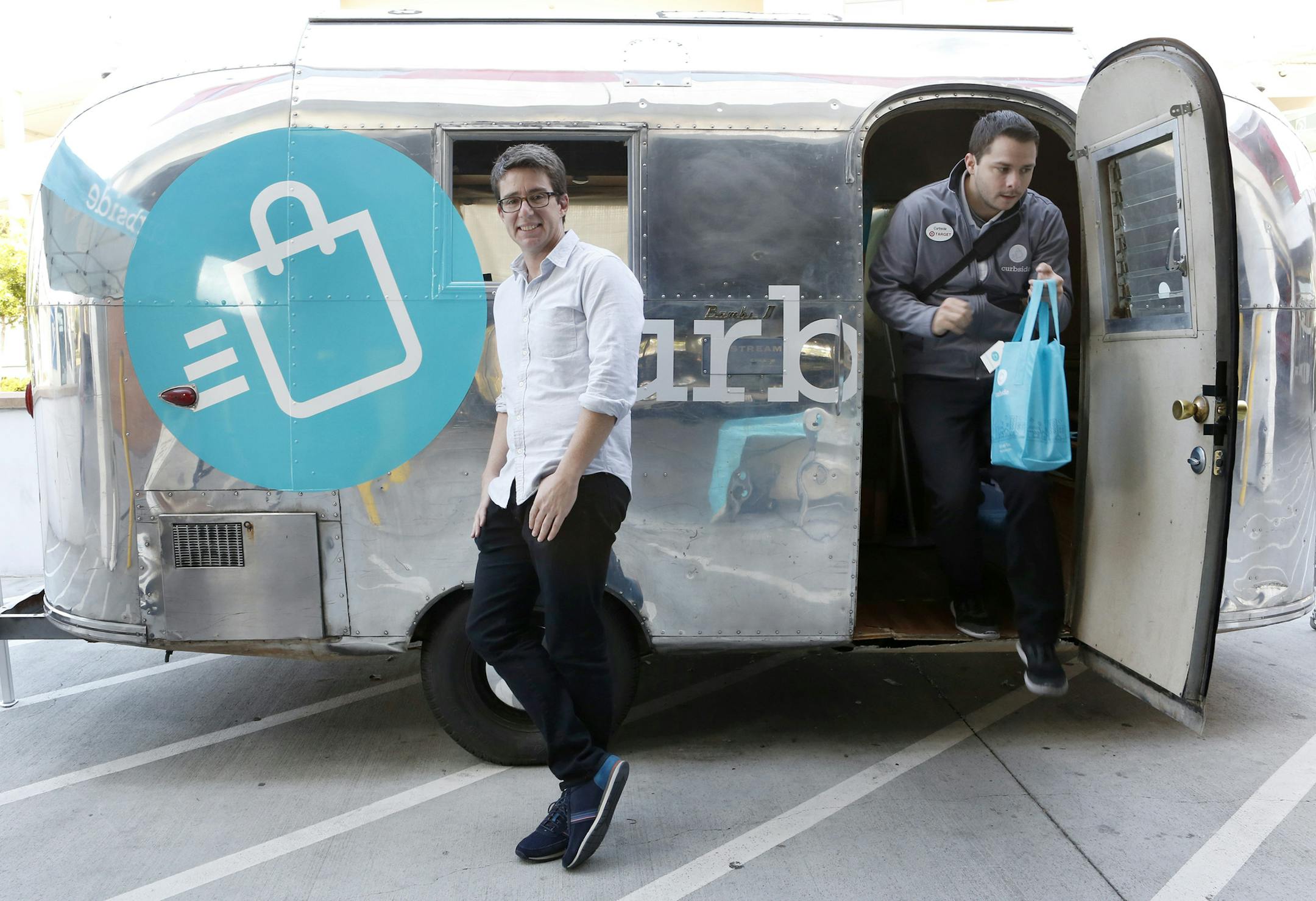 Jaron Waldman, founder and CEO of Curbside, with the company's Airstream trailer at the Target store in Sunnyvale, Calif., on May 13, 2015. Sales associate Paul Kamradt, right, heads for a shopping run. Waldman left Apple to create the Curbside shopping app, which helps shoppers buy products at retail stores such as Target without stepping foot in the store. (Gary Reyes/Bay Area News Group/TNS) ORG XMIT: 1169348