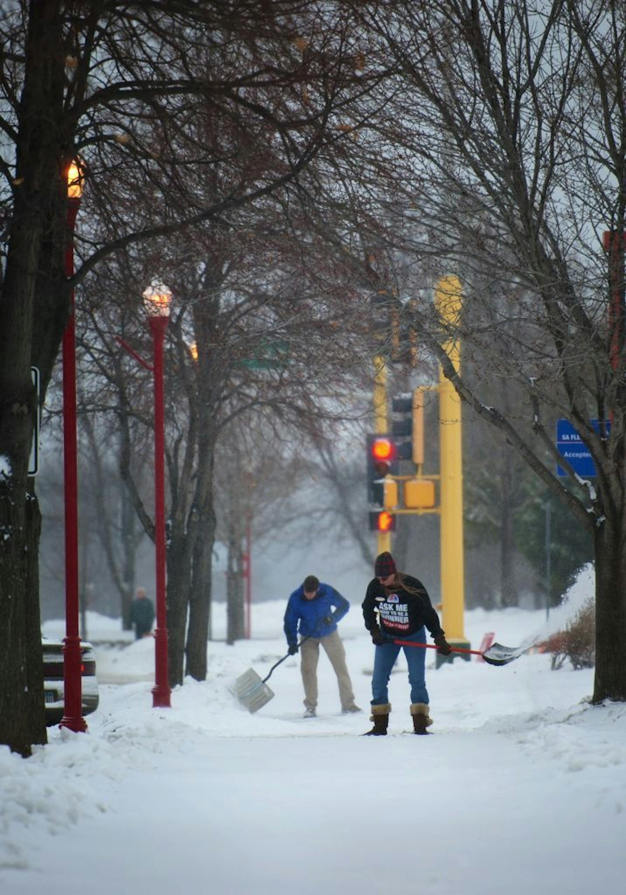 SuperAmerica employees cleared the sidewalk in front of their station in Apple Valley Thursday morning. The south suburbs received a couple of inches of snow while areas farther south were hammered with up to 16 inches. Thursday, December 20, 2012
