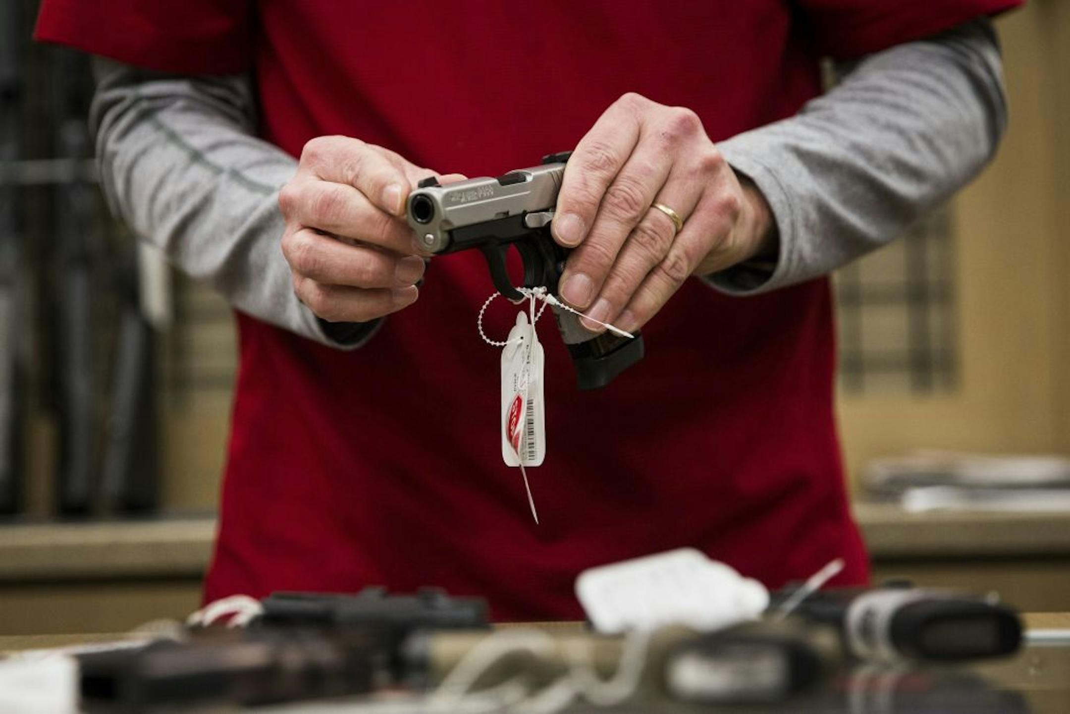 FILE -- An employee displays a handgun at a gun store in Johnston, Iowa, Jan. 22, 2016. The decision to buy a handgun for the first time raises the purchasersÕ risk of deliberately shooting themselves by ninefold on average, with the danger most acute in the weeks after purchase, scientists reported on June 3, 2020.