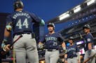 The Mariners' Cal Raleigh (29) celebrates with teammates after hitting a grand slam during the seventh inning against the Twins on Tuesday at Target F