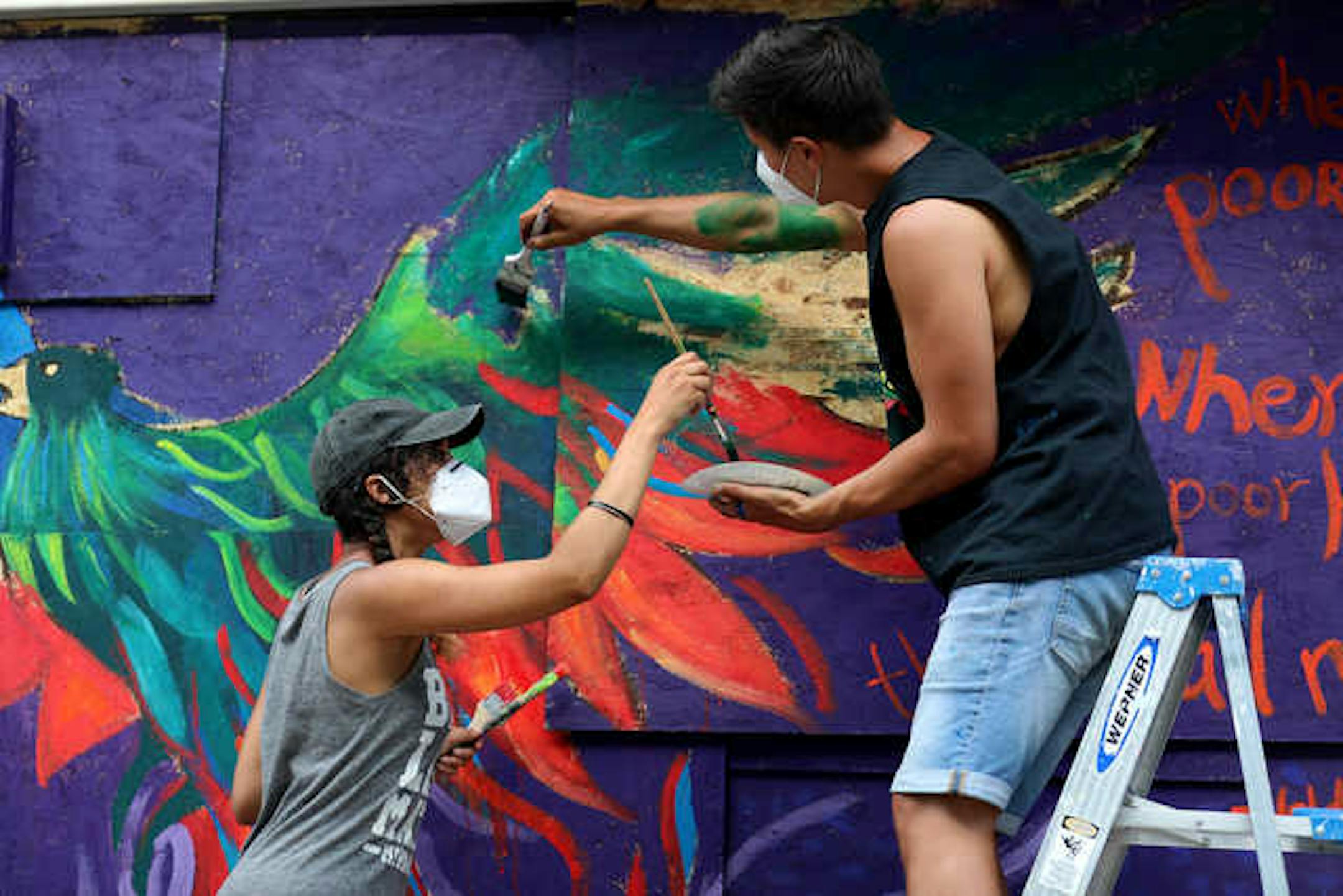 Local artist Leslie Barlow, left, and Ryan Stopera painted a mural on the boarded-up front of Fall Out Arts Initiative in Minneapolis' Whittier neighborhood.