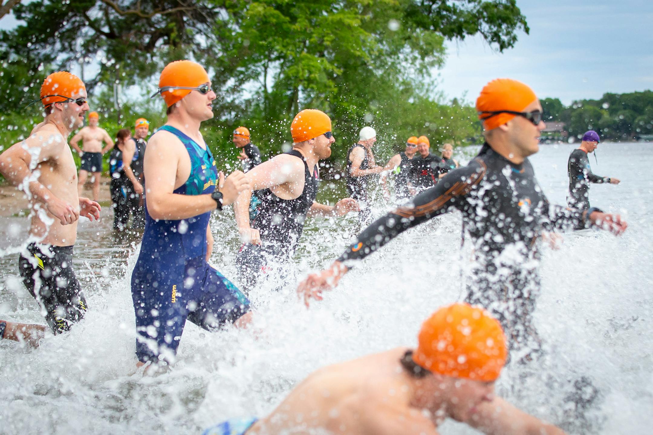 Participants of the 2024 Lake Minnetonka Triathlon run as spectators cheer them on. The event was cancelled this year after a safety dispute with city officials.