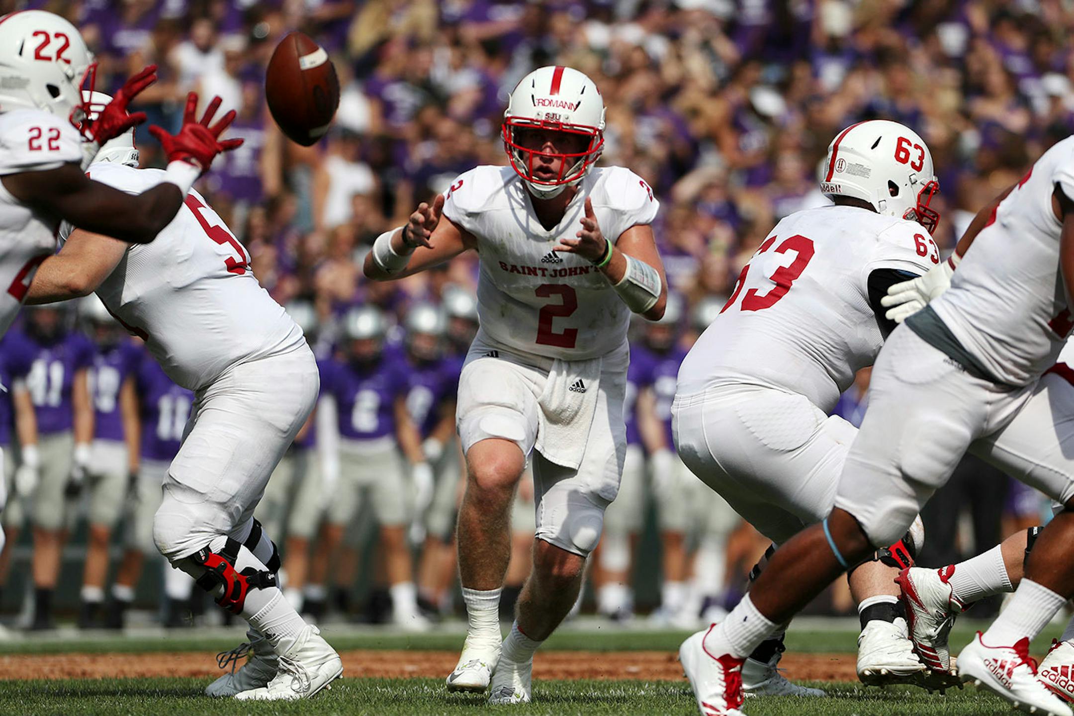 St. John's University quarterback Jackson Erdmann (2) threw the ball to St. John's University wide receiver Evan Clark (22) in the first half.