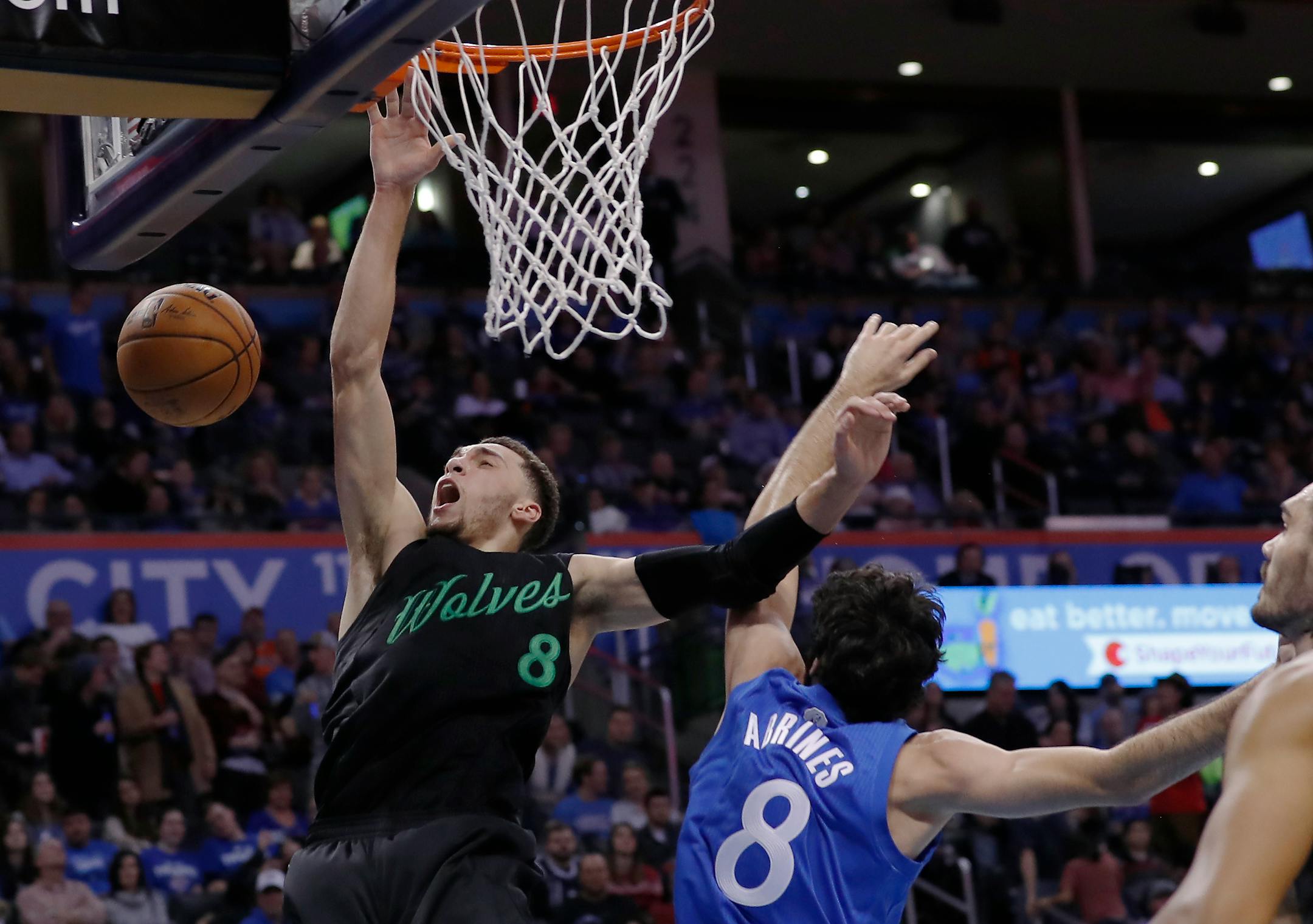 Minnesota Timberwolves guard Zach LaVine, left, is fouled by Oklahoma City Thunder guard Alex Abrines, right, on the way to the basket during the first half of an NBA basketball game in Oklahoma City, Sunday, Dec. 25, 2016. (AP Photo/Alonzo Adams)