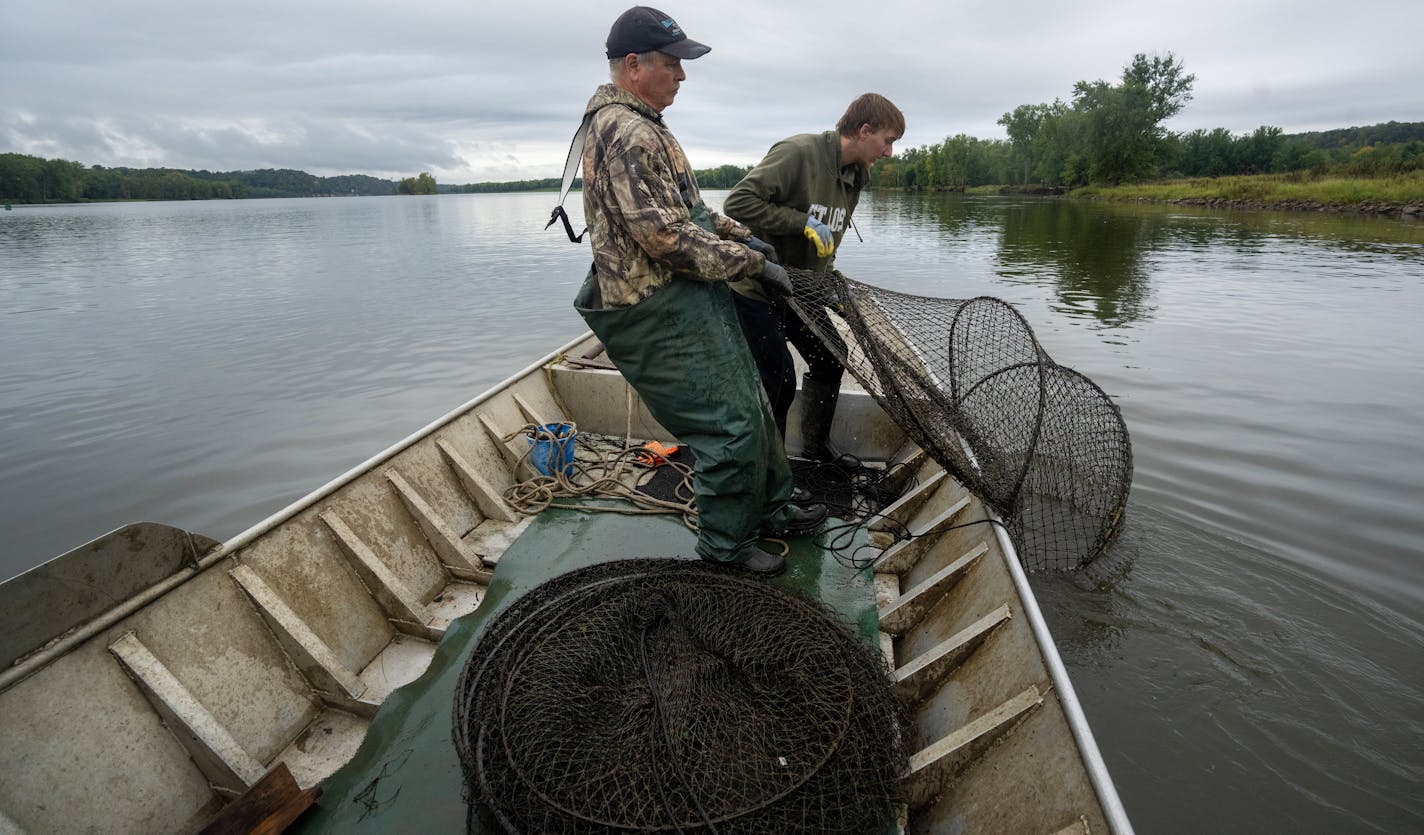 Mike Valley, left, and his grandson, Bryce Priebe, haul in a net Sept. 26 on the Mississippi River near Cassville, Wisconsin. Valley is one of the last commercial fishermen on the upper Mississippi River, and has seen many changes to the river in the decades he's fished it. Credit: Mark Hoffman, Milwaukee Journal Sentinel