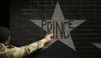 After kissing his fingers, a fan touches Prince's star on the wall of First Avenue in Minneapolis on Thursday, April 21, 2016. (Jeff Wheeler/Minneapol