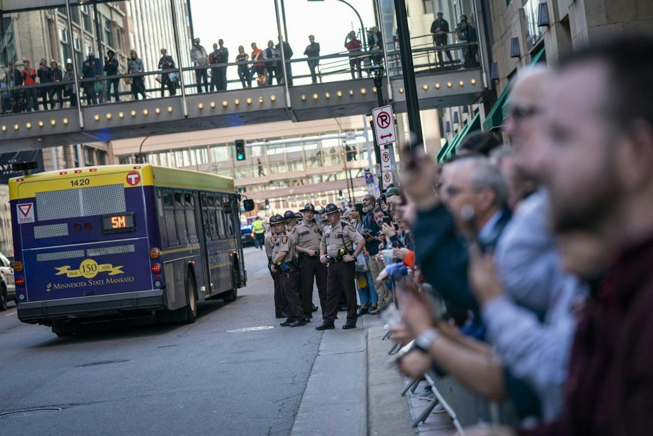 University of Virginia fans wait outside the Marquette Hotel in downtown Minneapolis for their basketball team to board the bus as law enforcement keeps tight security.