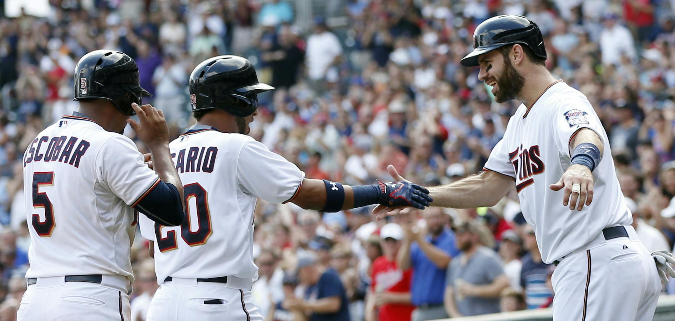 Minnesota Twinsí Joe Mauer, right, greets Eddie Rosario, center, after Rosario's grand slam off Chicago White Sox pitcher Jeff Samardzija in the third inning of a baseball game, Thursday, Sept. 3, 2015, in Minneapolis. (AP Photo/Jim Mone)
