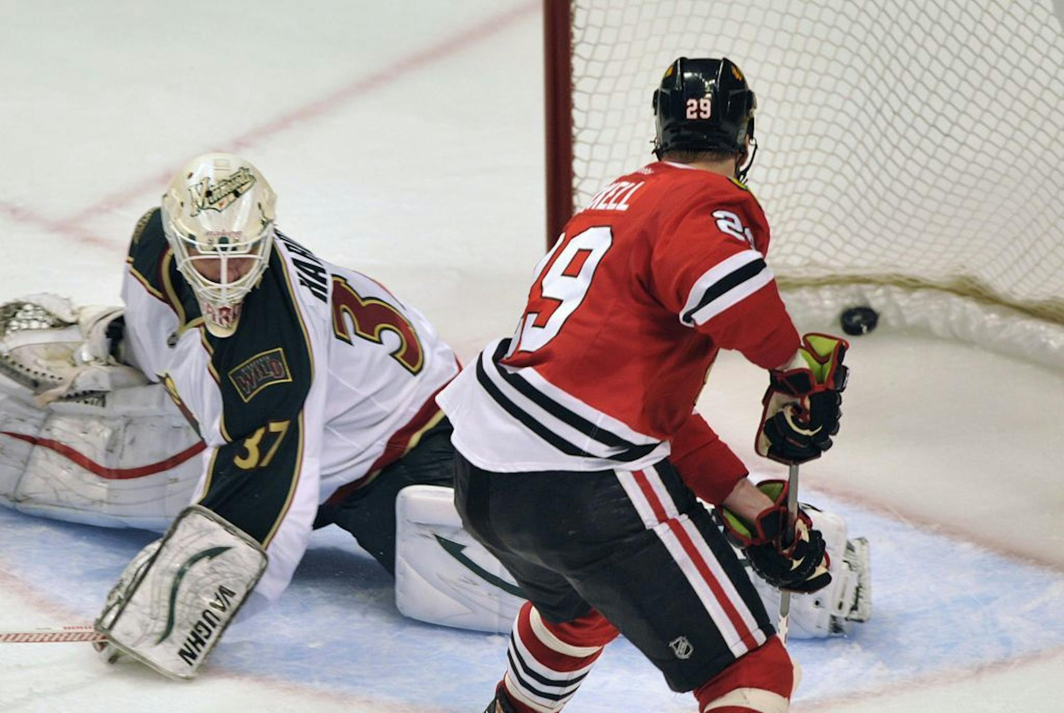 Chicago Blackhawks' Bryan Bickell right, shoots the game-winning goal past Minnesota Wild's Josh Harding
