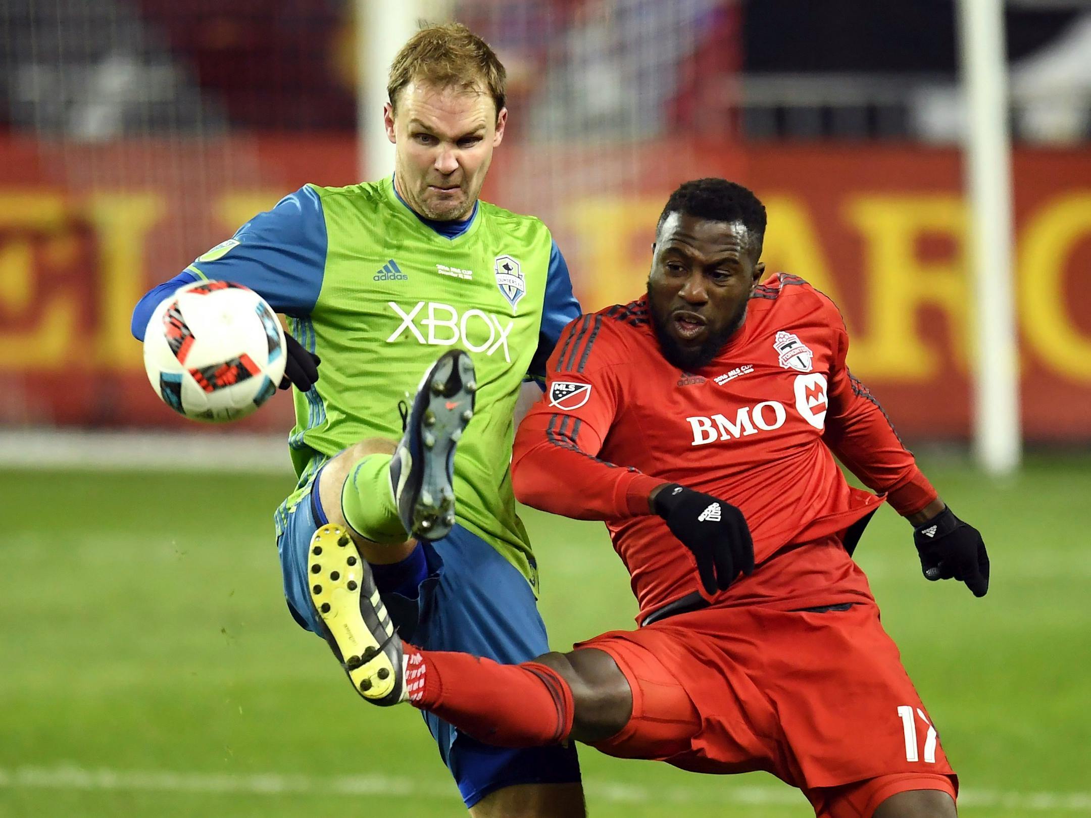 Seattle Sounders defender Chad Marshall, left, and Toronto FC forward Jozy Altidore (17) battle for the ball during second-half MLS Cup final soccer action in Toronto, Saturday, Dec. 10, 2016. (Franks GunnThe Canadian Press via AP)