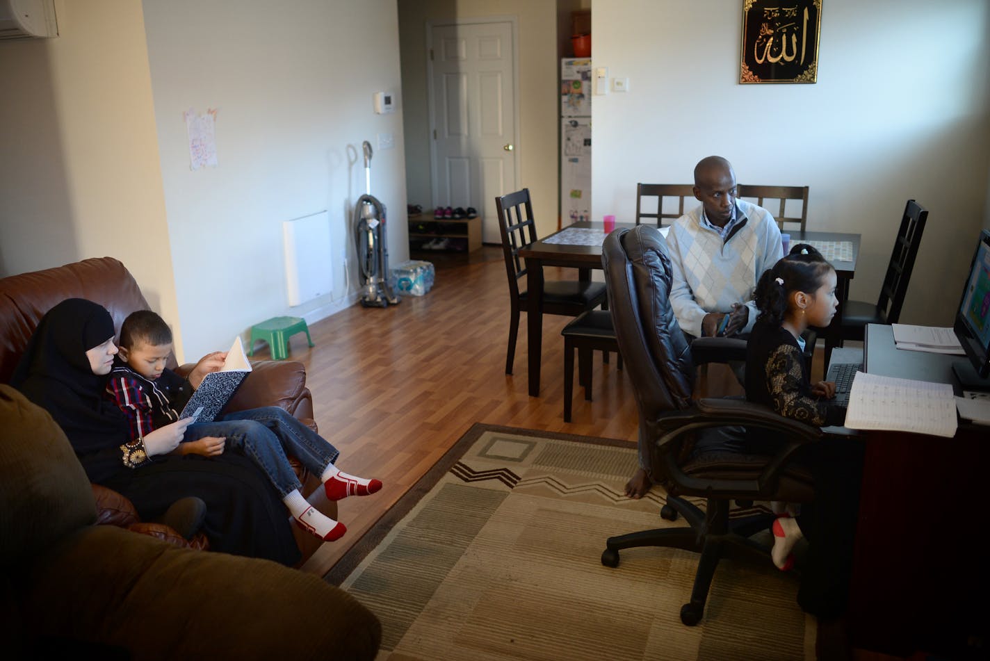 Sarah Olson helped her 7-year old son, Jamal, with Arabic homework as husband Mohamed Abdi watched his daughter Sofia complete math problems on Saturday afternoon. ] (AARON LAVINSKY/STAR TRIBUNE) aaron.lavinsky@startribune.com A newly released study by the Wilder Foundation of families that have moved into Habitat for Humanity homes reads like a litany of good news. Habitat families report a host of positive impacts from their move. More than half say their kids are doing better in school; more