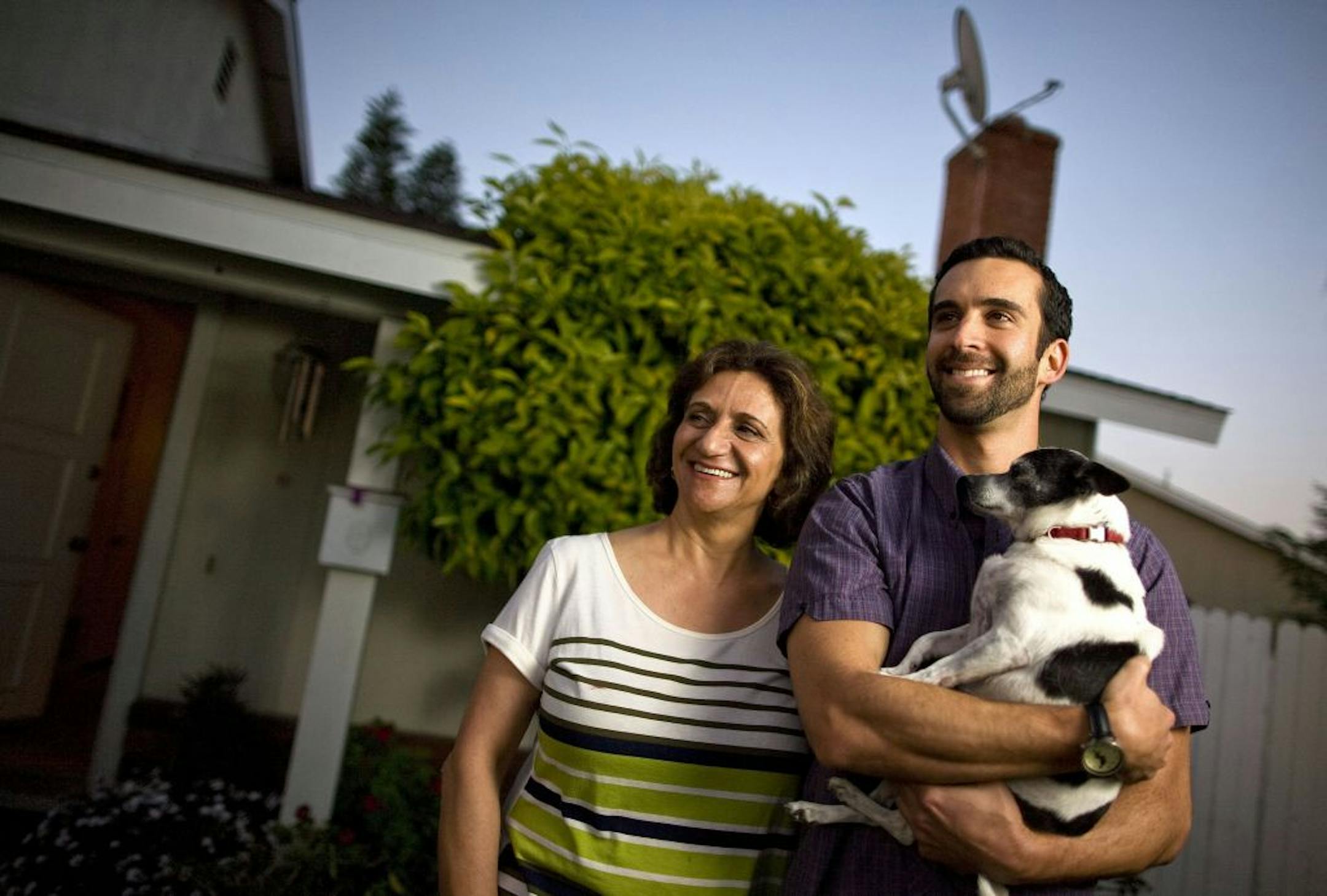 Huntington Beach, Calif., resident Bobby Waltman, 29, right, holds onto his Chihuahua mix, Mooshy. Waltman is a lawyer living with his mother, Nasrin Waltman, left, and his grandmother. He passed the bar in December 2013 and is currently an associate attorney at a personal injury firm, however, he's faced financial difficulty due to his $85,000 in pre-law and law school loans.