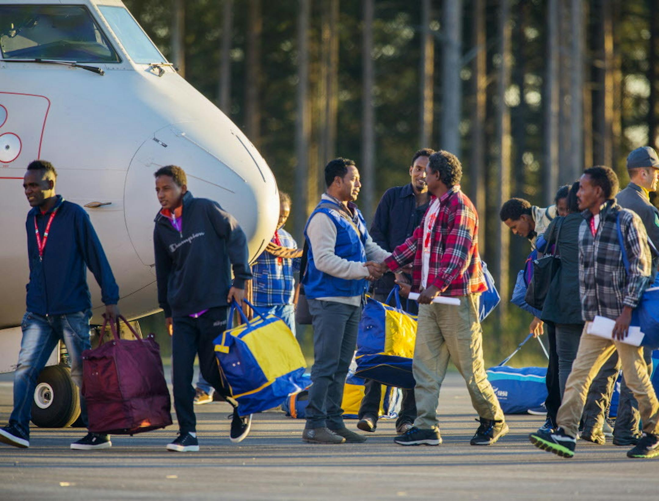 Eritrean asylum seekers arrive by an Italian Financial police aircraft to Lulea Airport, Kallax northern Sweden, Friday, Oct. 9, 2015. Italy bid farewell Friday to 19 Eritreans ó the first of an estimated 160,000 refugees to be resettled throughout Europe as part of a new EU redistribution program to move asylum-seekers out of hard-hit front-line countries. Bundled up in flannel shirts and jackets to prepare for their new lives in Sweden they landed in Lulea, just south of the Arctic Circle