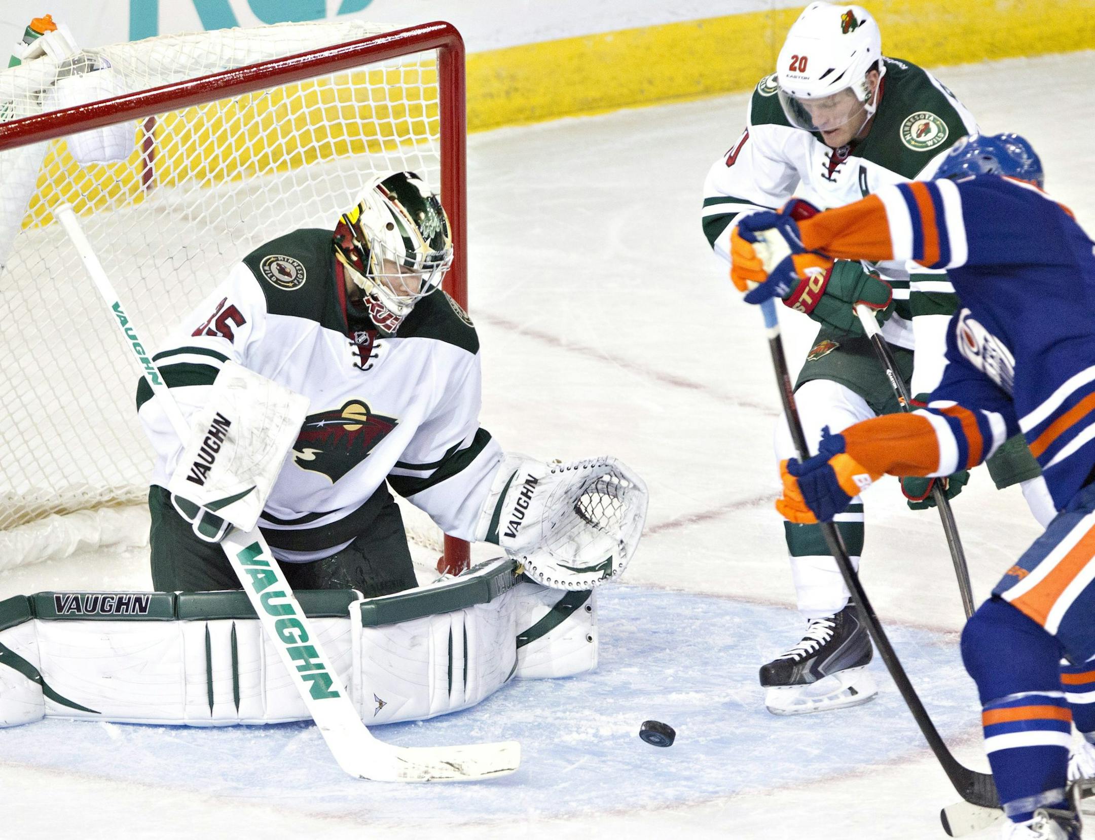 Minnesota Wild's goalie Darcy Kuemper (35) makes the save on Edmonton Oilers' Sam Gagner (89) as Ryan Suter (20) tries to defend during third period NHL hockey action in Edmonton, Alberta, on Thursday Feb. 27, 2014. (AP Photo/The Canadian Press, Jason Franson)