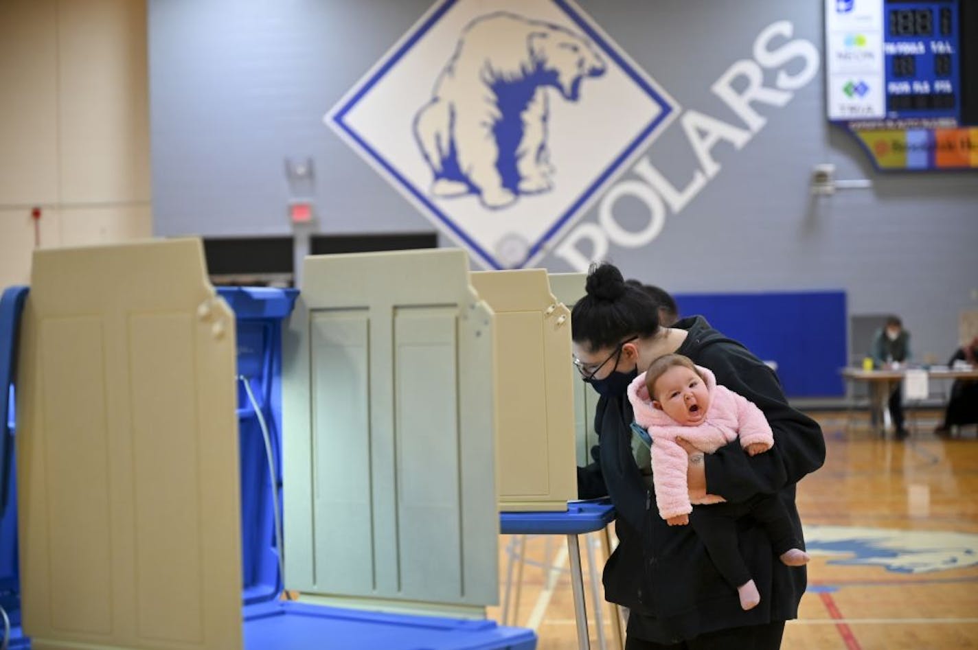 Alycia Howard, 22, of north Minneapolis, held her yawning 3-month old daughter, Alivia, as she filled out her ballot in North High School's gymnasium Tuesday night in Minneapolis.