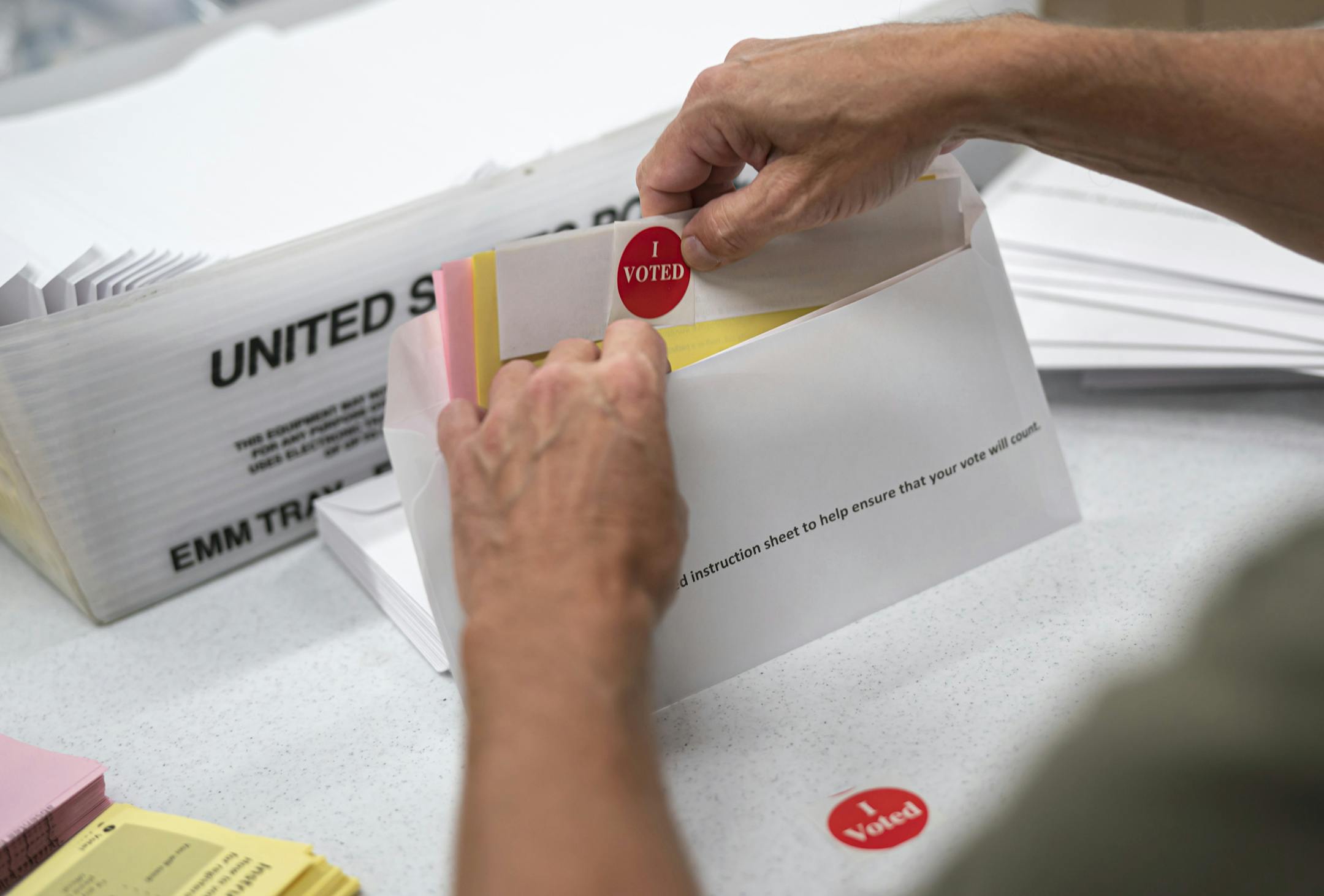 FILE - In this July 29, 2020, file photo, mail in ballot envelopes including an I Voted sticker are prepared in Minneapolis. Nevada's new vote-by-mail law includes provisions allowing anyone to collect and return ballots on a voter's behalf, a practice critics deride as ballot harvesting and that President Donald Trump and Republicans are targeting amid a broader fight over voting amid the pandemic. (Glen Stubbe/Star Tribune via AP, File)/Star Tribune via AP)