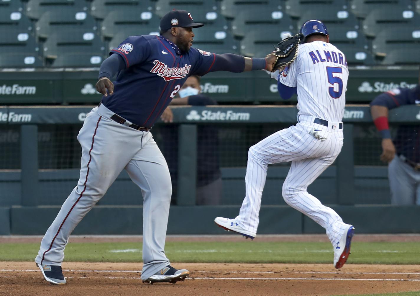 Minnesota Twins first baseman Miguel Sano tags out Chicago Cubs' Albert Almora Jr. during the fourth inning of a summer camp baseball game Wednesday, July 22, 2020, in Chicago. (AP Photo/Charles Rex Arbogast)