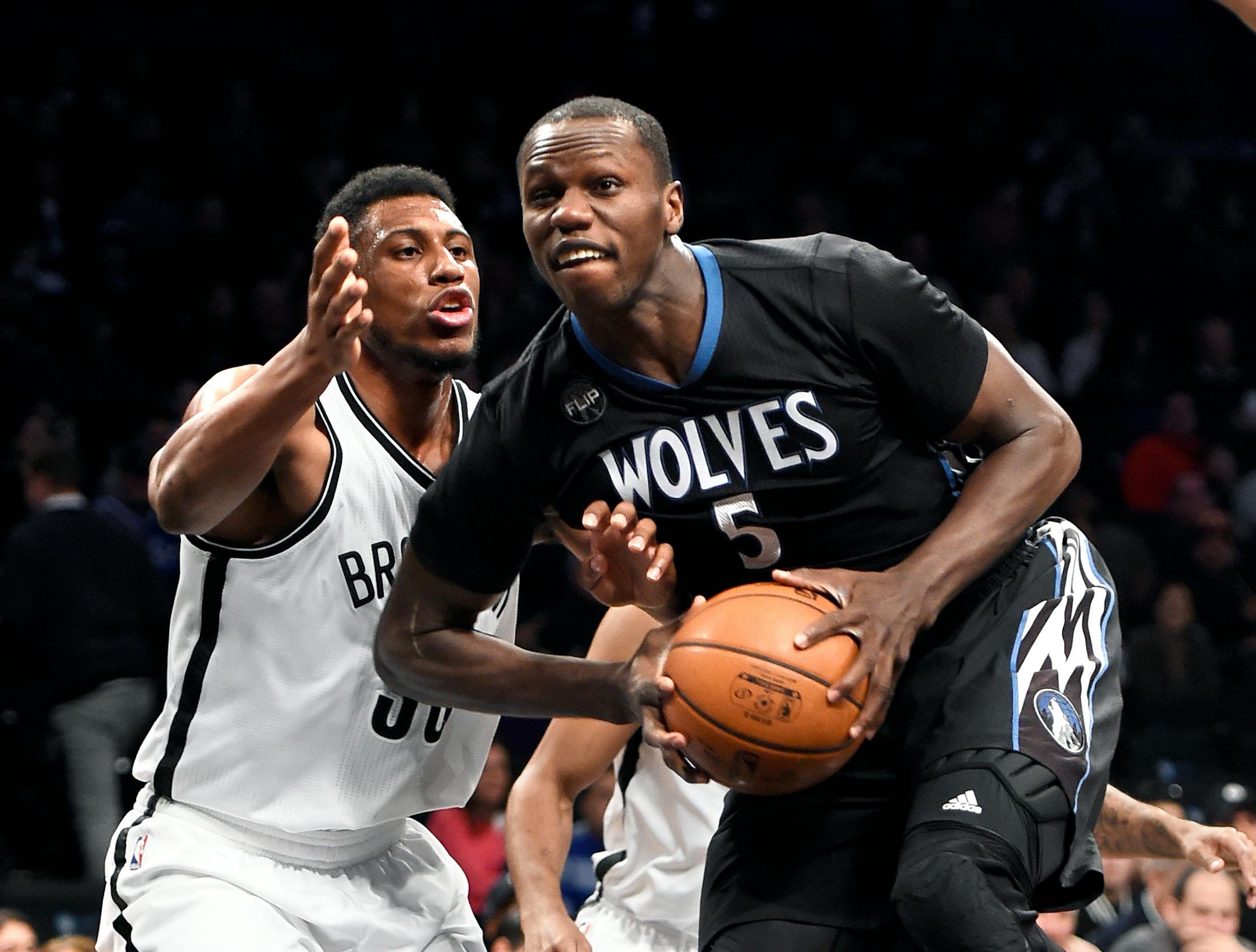 Minnesota Timberwolves center Gorgui Dieng (5) drives the ball around Brooklyn Nets forward Thaddeus Young (30) during the first half of an NBA basketball game on Sunday, Dec. 20, 2015, in New York. The Timberwolves won 100-85. (AP Photo/Kathy Kmonicek)
