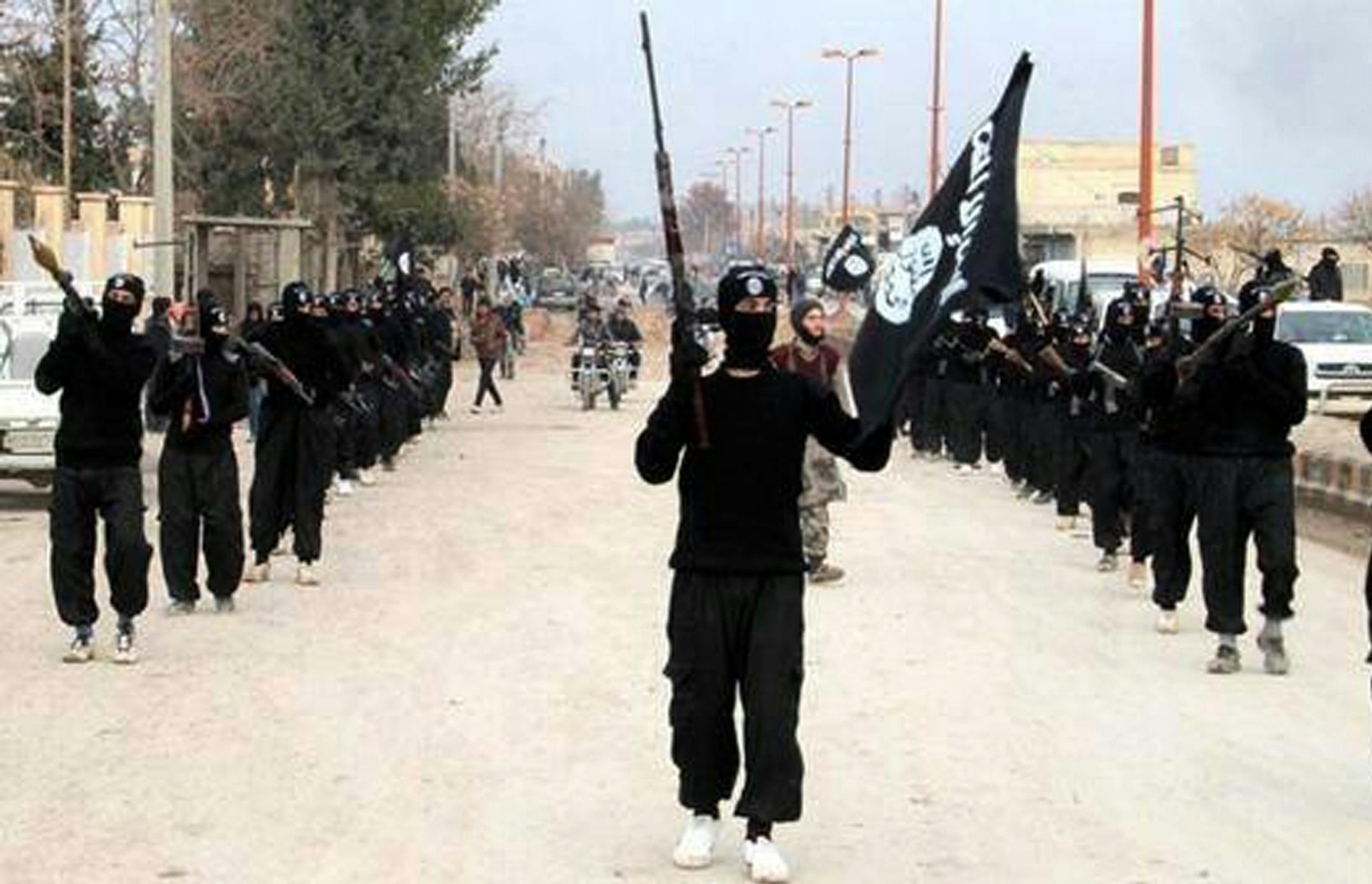 This undated image posted on a militant website on Tuesday, Jan. 14, 2014 shows fighters from the al-Qaida linked Islamic State of Iraq and the Levant (ISIL) marching in Raqqa, Syria.