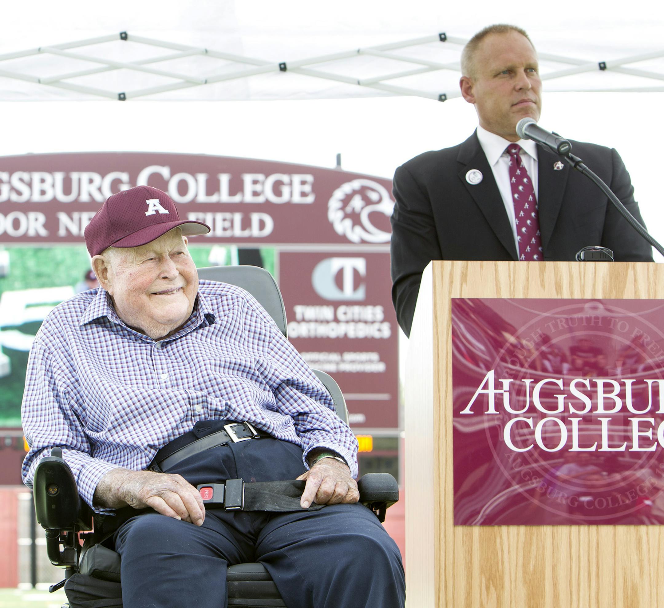 Athletic Director Jeff Swenson, right, speaks about guest of honor Edor Nelson, left, at the dedication ceremony for the new scoreboard named in Nelson's honor at Augsburg College in Minneapolis August 18, 2014. Nelson also turned 100 years old Monday. (Courtney Perry/Special to the Star Tribune)